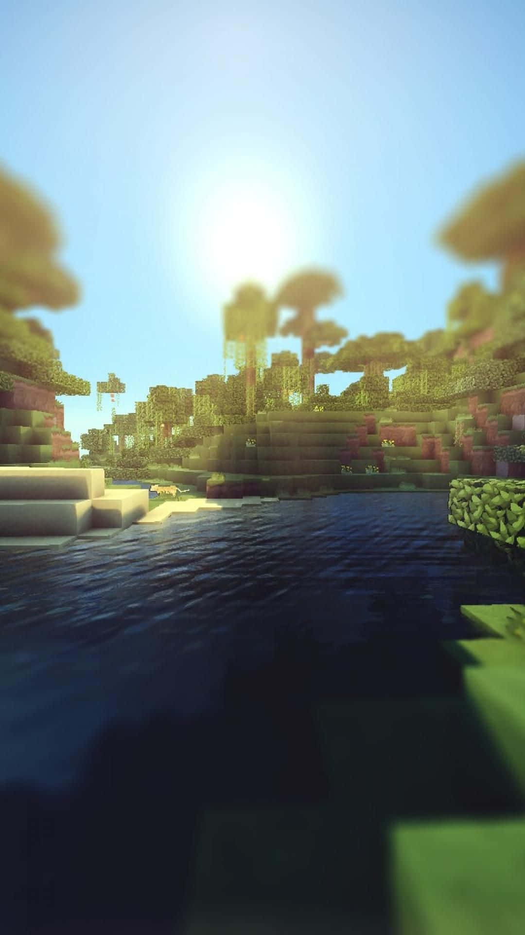 Minecraft Phone 桌布 壁紙 — 陽光在一個由方塊樹木和地形環繞的像素化Minecraft湖面上閃耀。