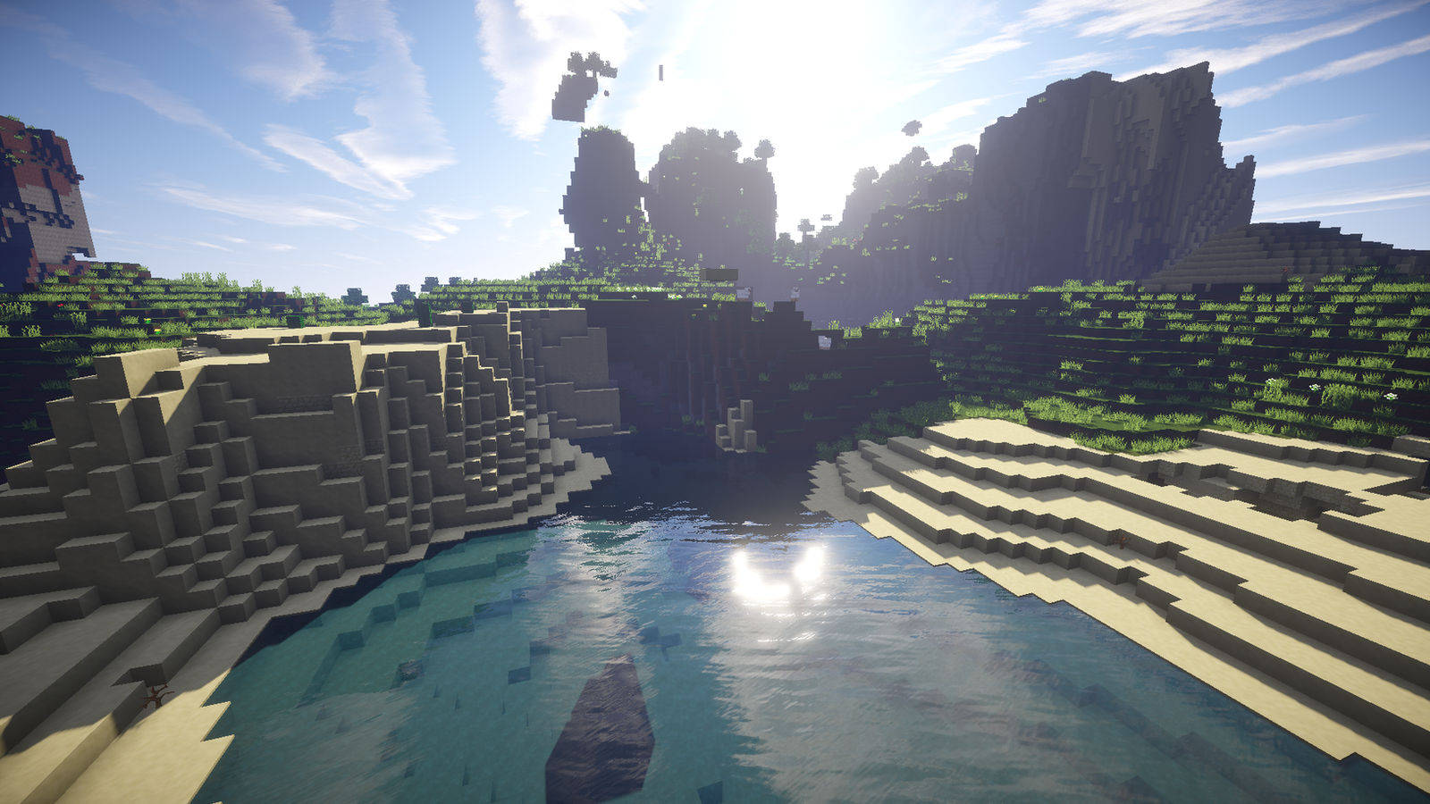 Minecraft HD 桌布 壁紙 — 陽光明媚的 Minecraft 峽谷，有塊狀懸崖、綠植和一個平靜的藍色水池，倒映著明亮的天空。