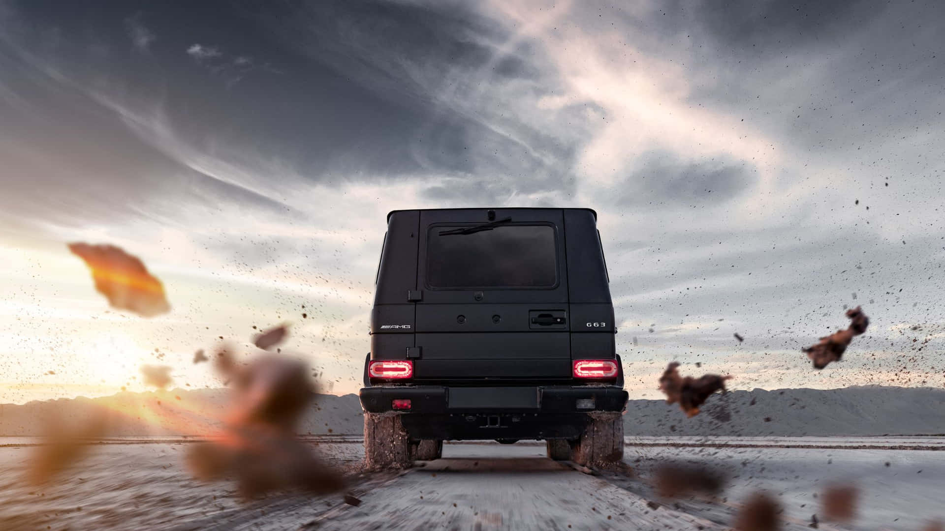 黑色 Mercedes G63 AMG 在沙漠中行駛，日落時塵土飛揚。
