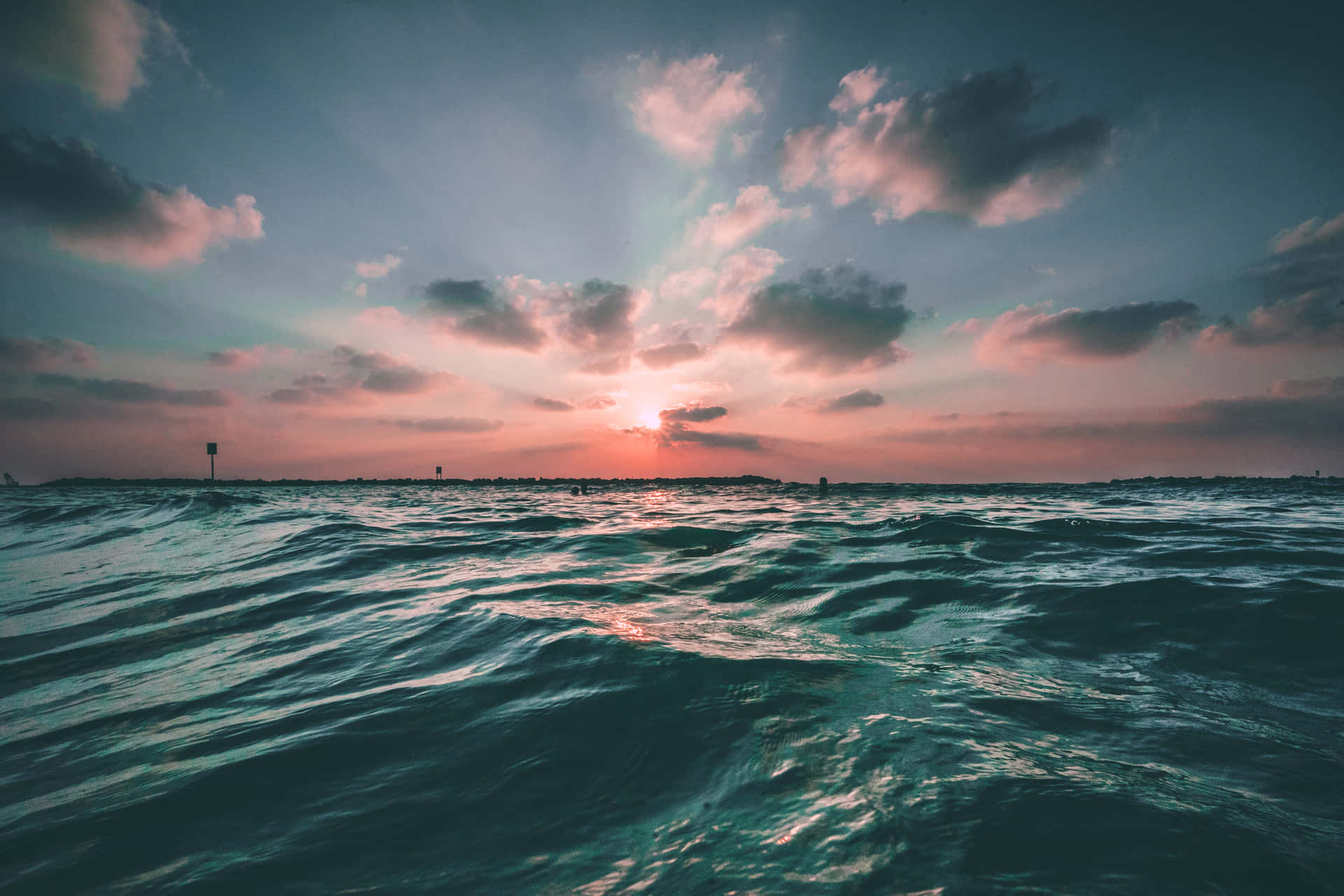 海上夕陽，波光粼粼的水面和遠處的剪影