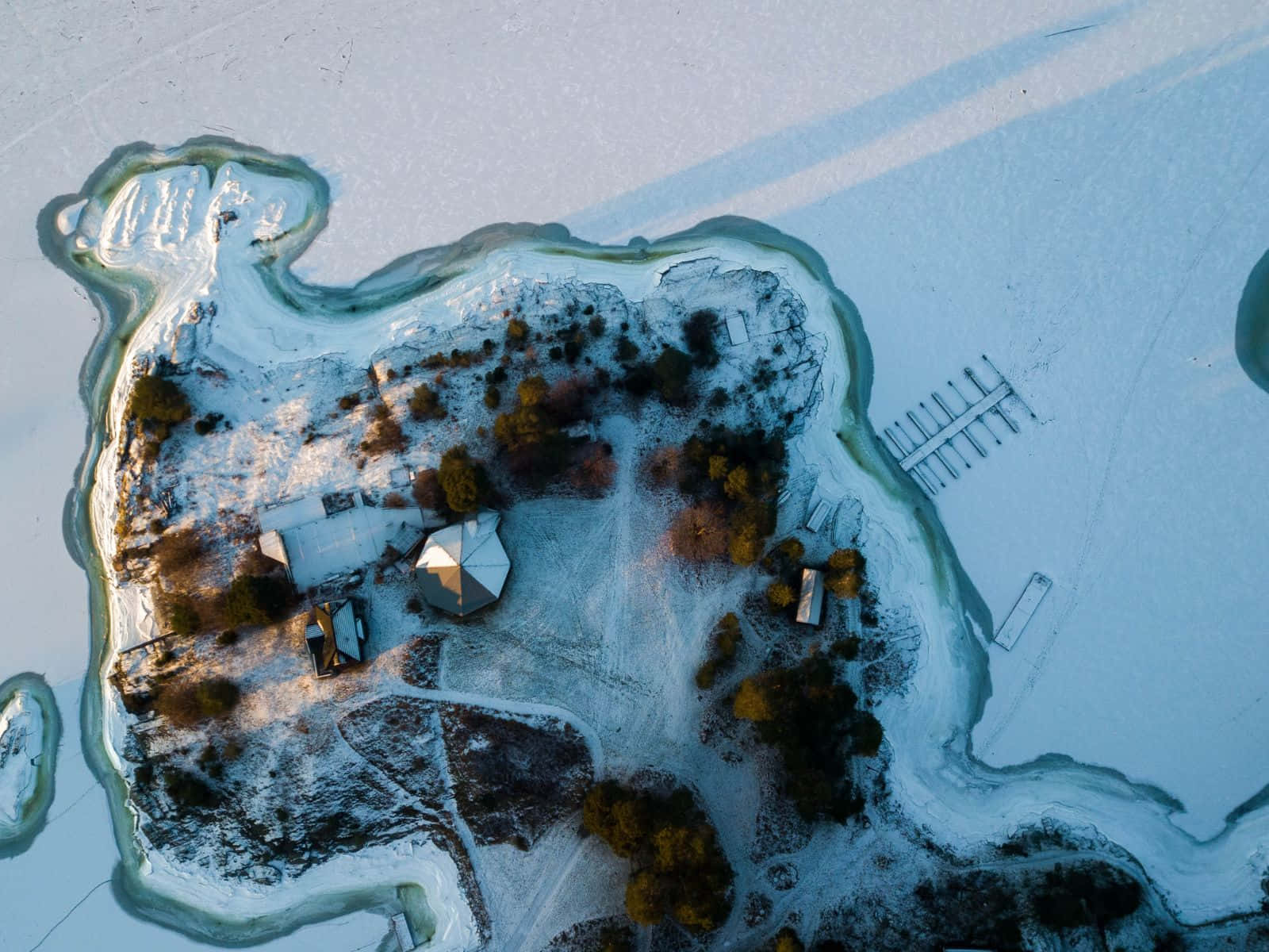 黃金時刻光線下的雪島、小屋和樹木。