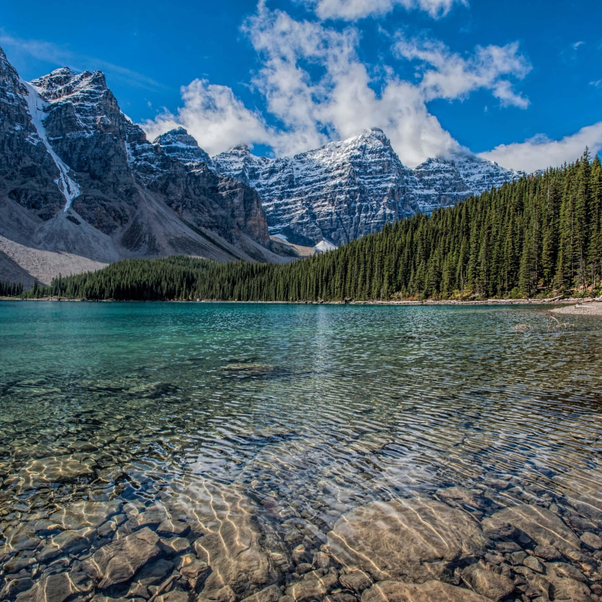 寧靜的高山湖泊，湖水清澈，藍天下有白雪覆蓋的山峰。