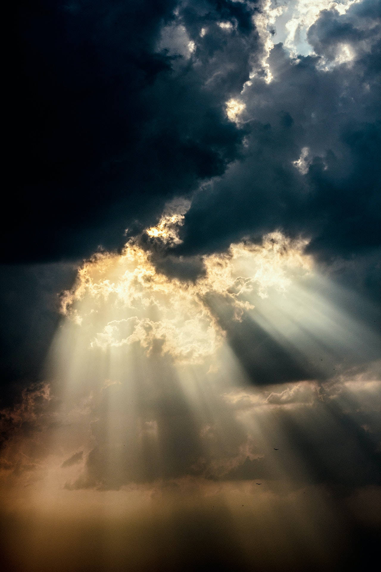 陽光穿透黑暗的暴風雲，在戲劇性的天空中閃耀。