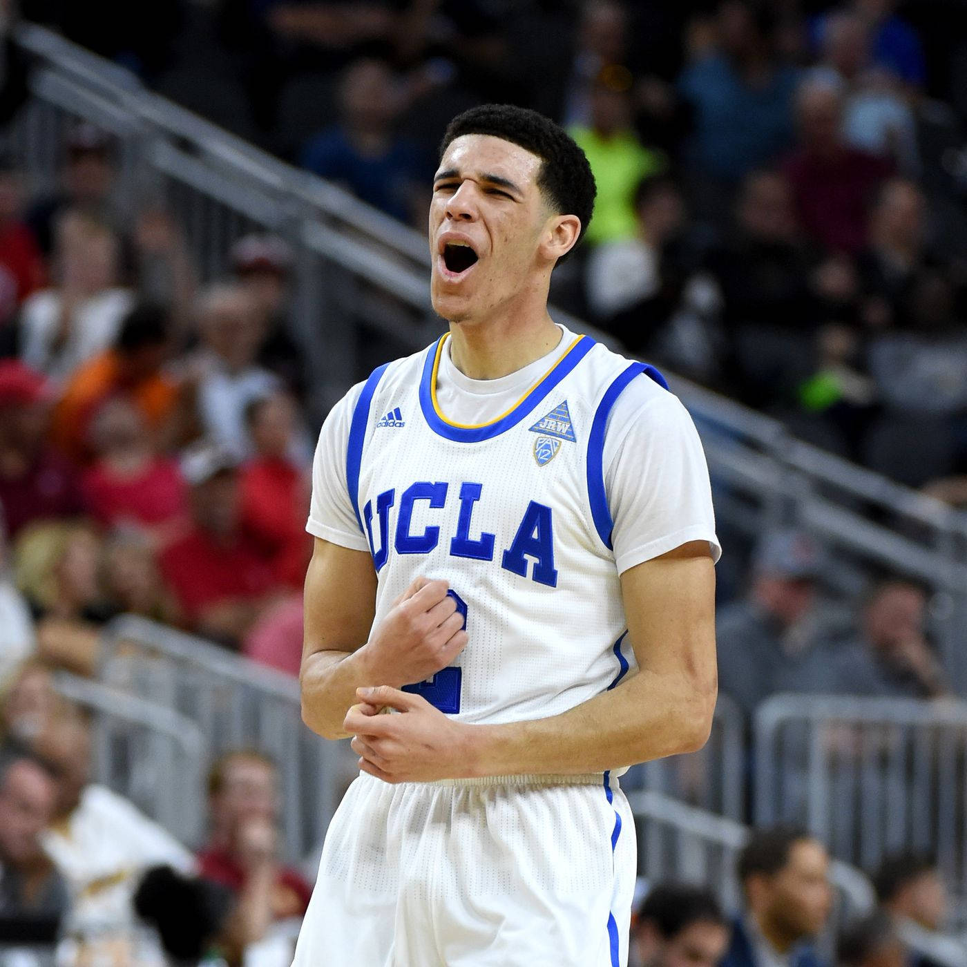 UCLA籃球運動員在比賽中激情吶喊，背景有觀眾。