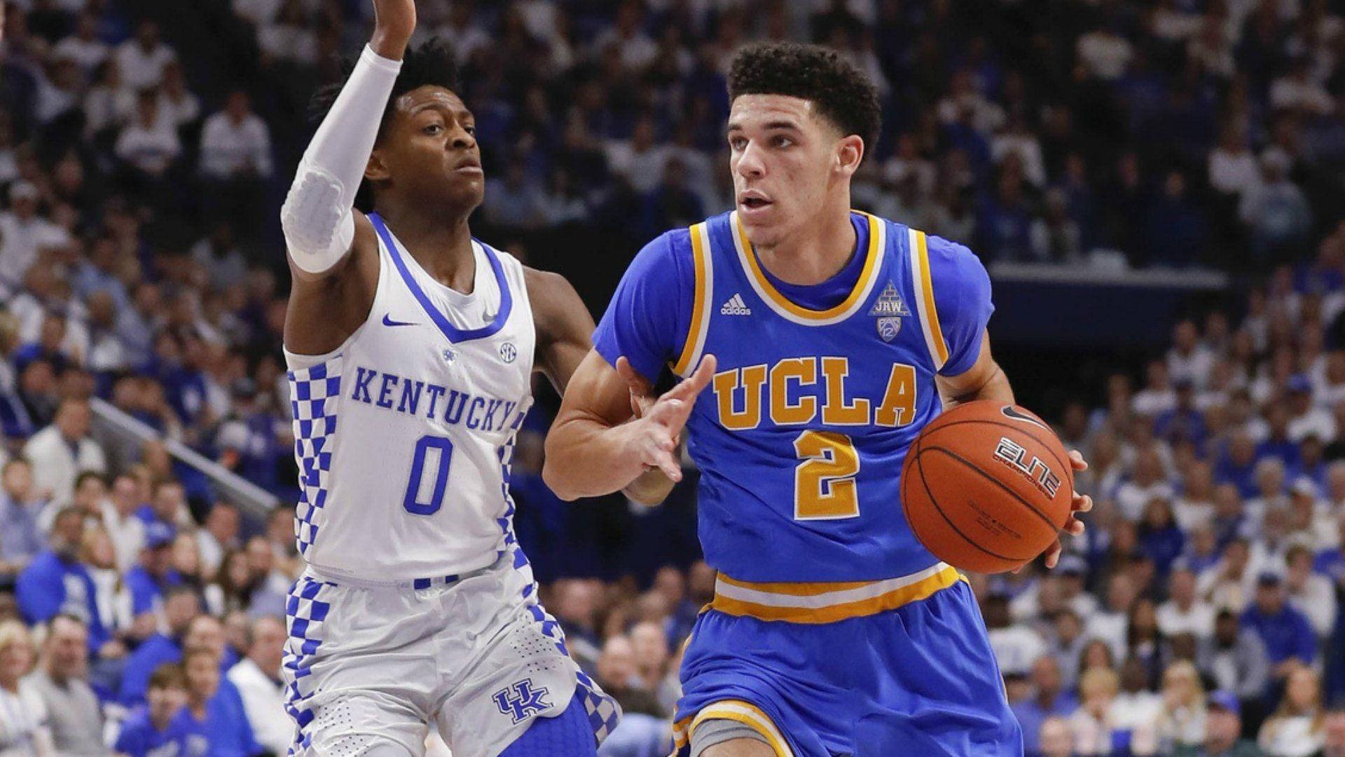 UCLA籃球運動員在擠滿觀眾的場館中運球越過肯塔基防守球員。