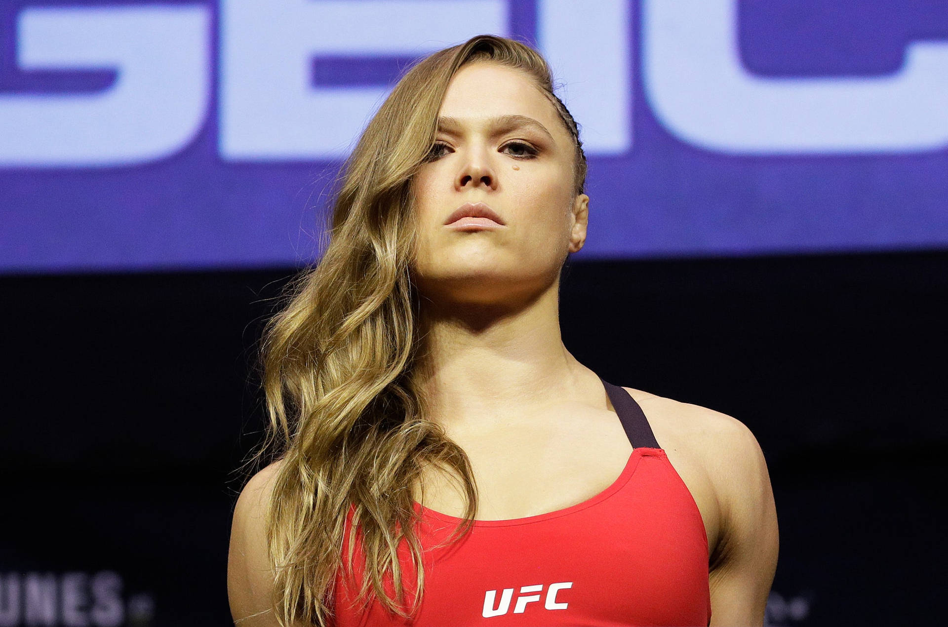 穿著紅色上衣的女性UFC拳手在稱重活動中。