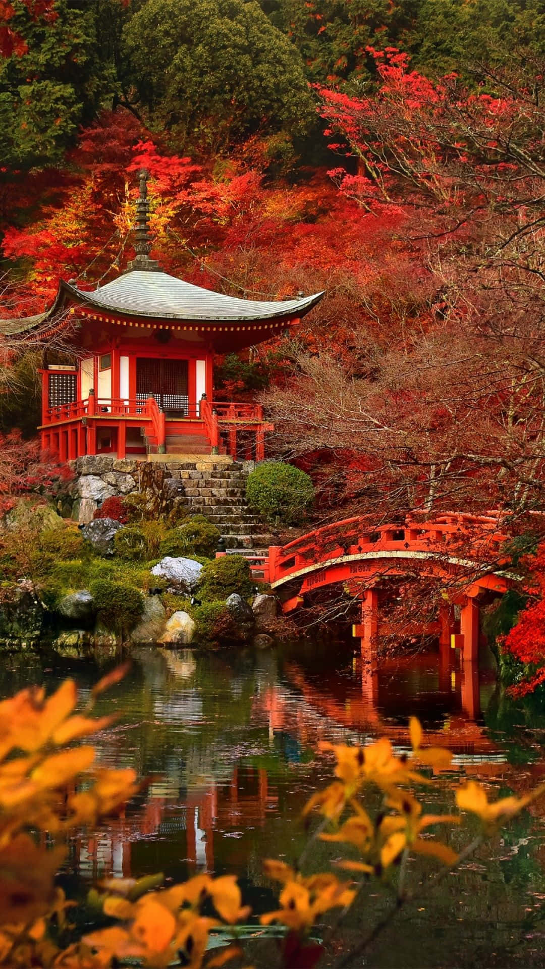 紅色寶塔和橋樑倒映在池塘中，伴有秋葉