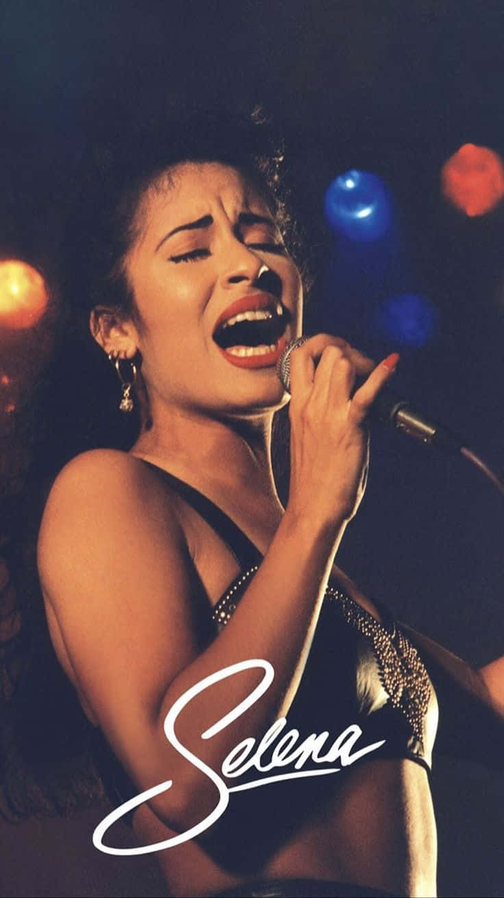 Selena Quintanilla 在舞台上表演，燈光色彩繽紛，她的名字寫在下方。