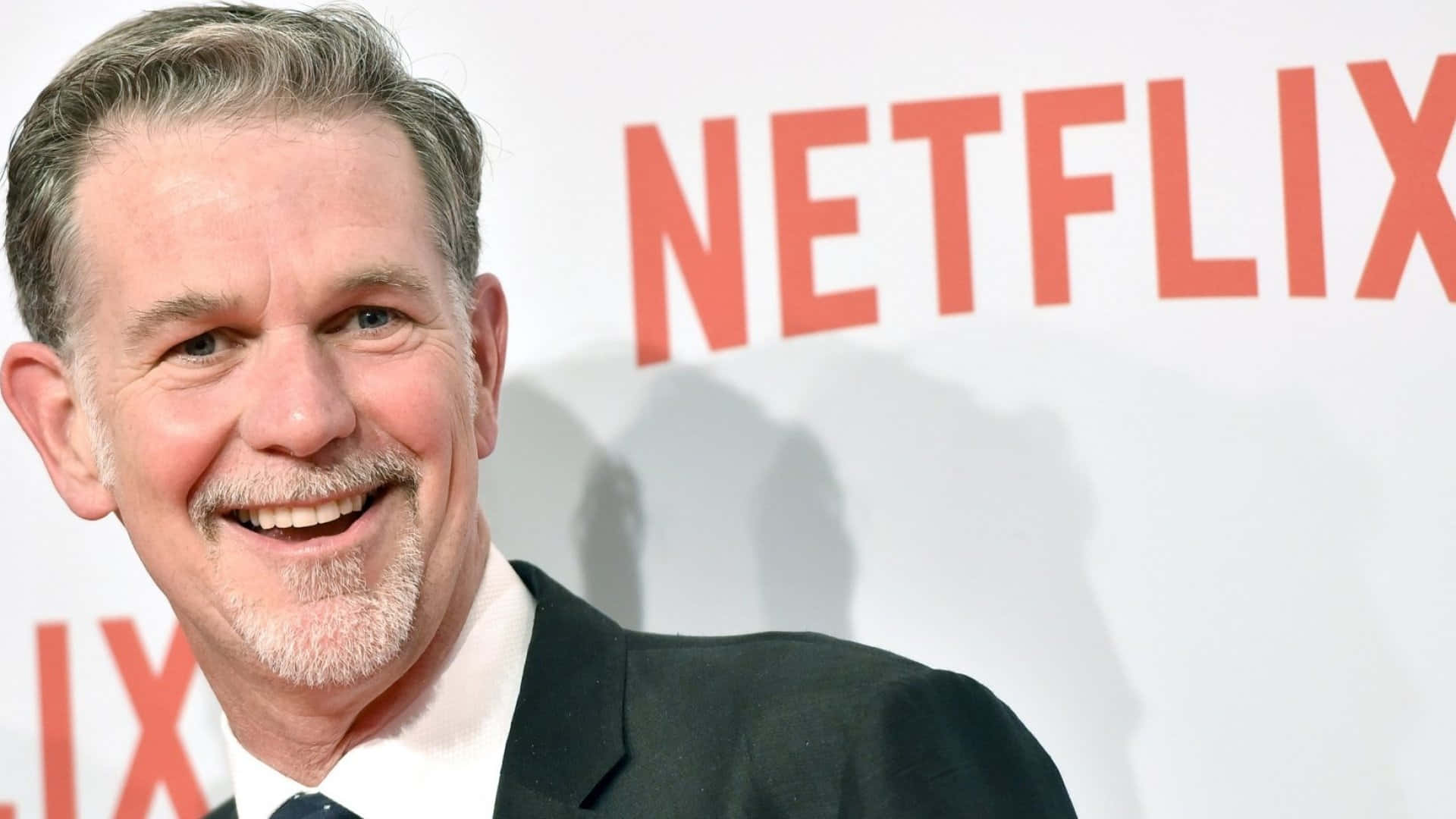 西裝男士在Netflix活動中對著鏡頭微笑。