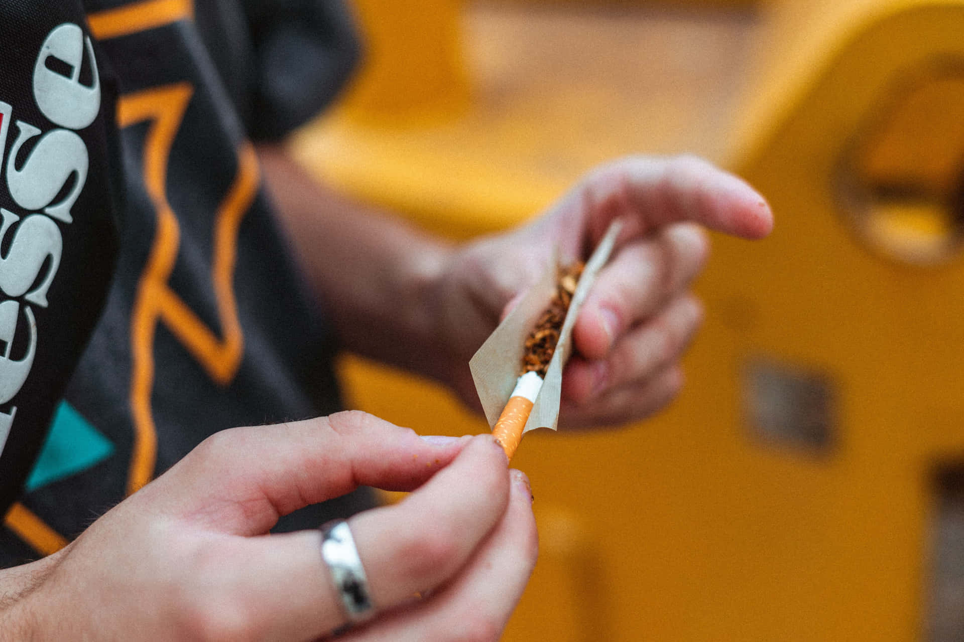 戴著戒指的手在捲煙。