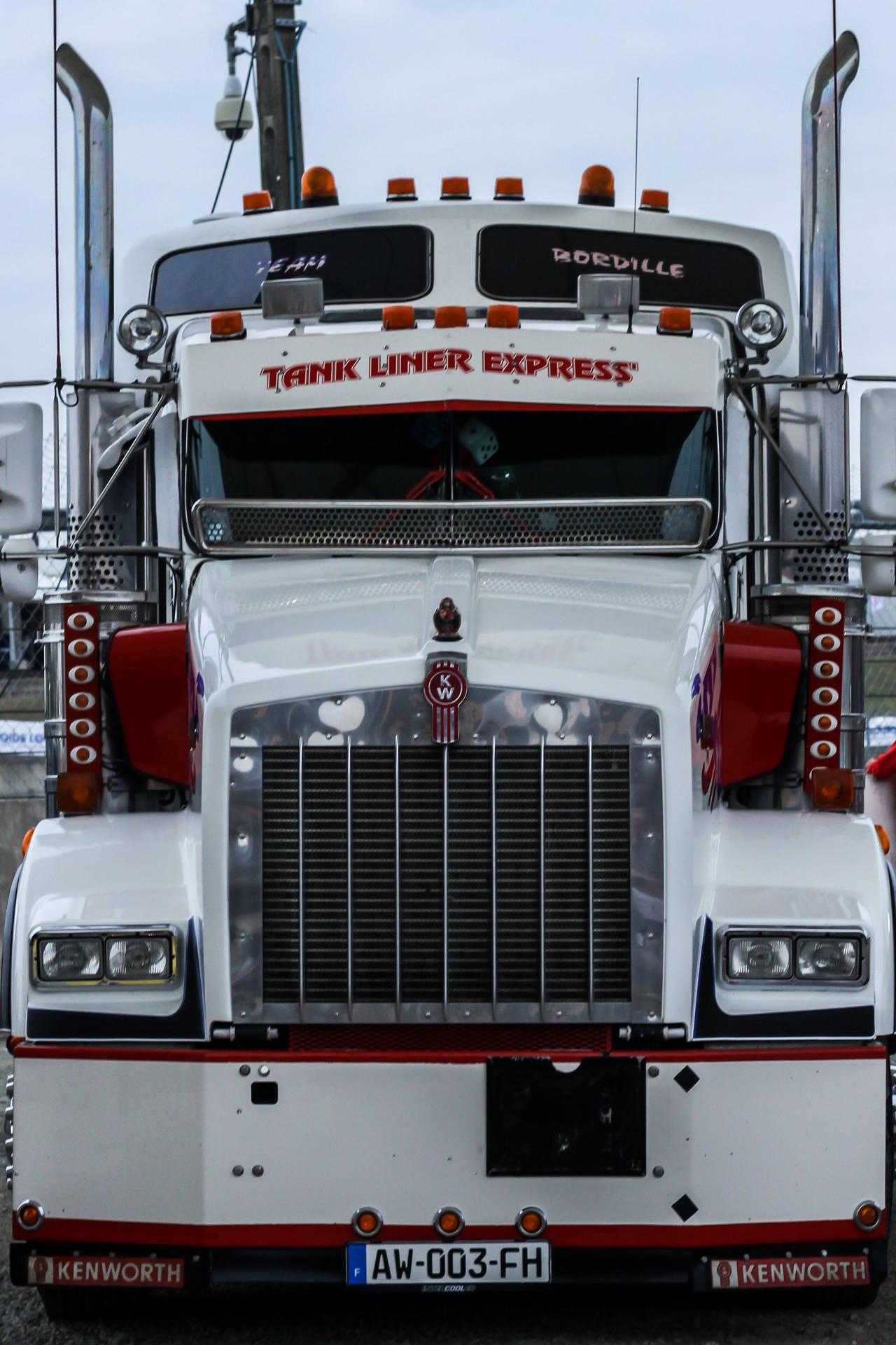 白色Kenworth油罐車的前視圖，帶有紅色飾邊和「Tank Liner Express」文字。
