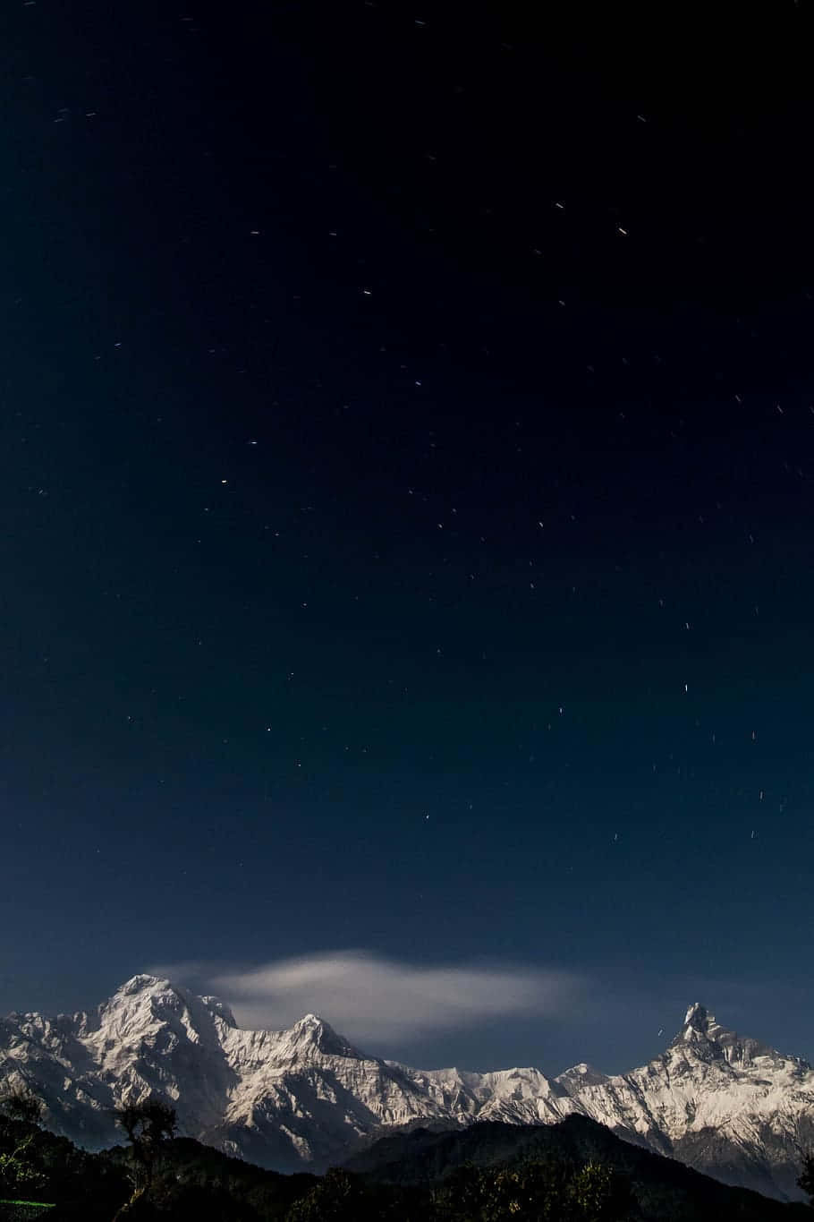 繁星夜空下的雪山山脈，帶有一朵發光的雲。