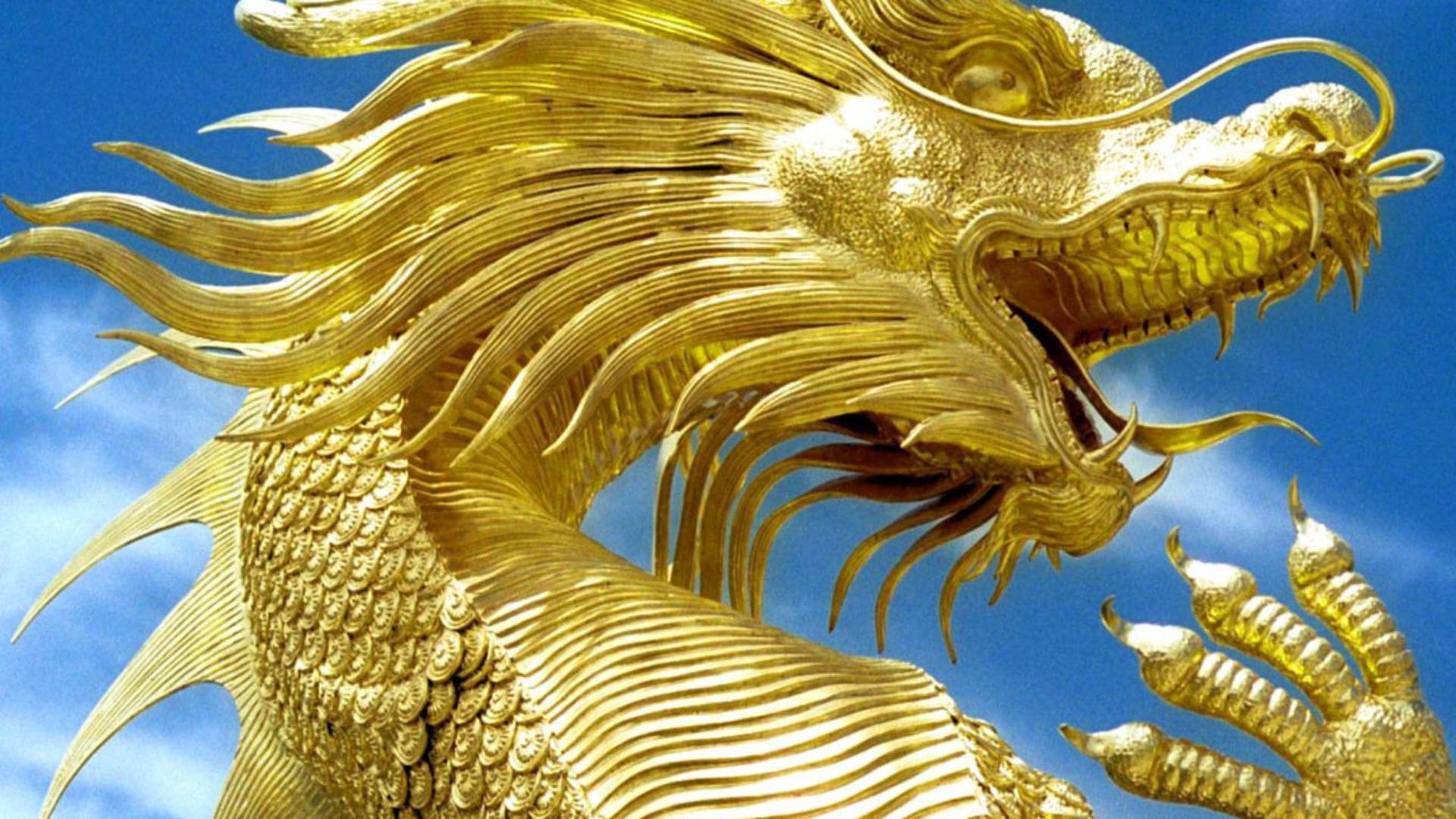 雄偉金龍雕塑 壁紙 — 一尊雄偉的金龍雕像，鱗片精緻，鬃毛飄逸，映襯著明亮的藍天。