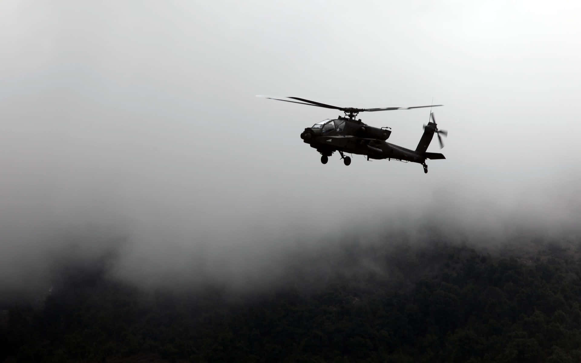 軍用直升機在黎明時分飛越霧氣籠罩的森林