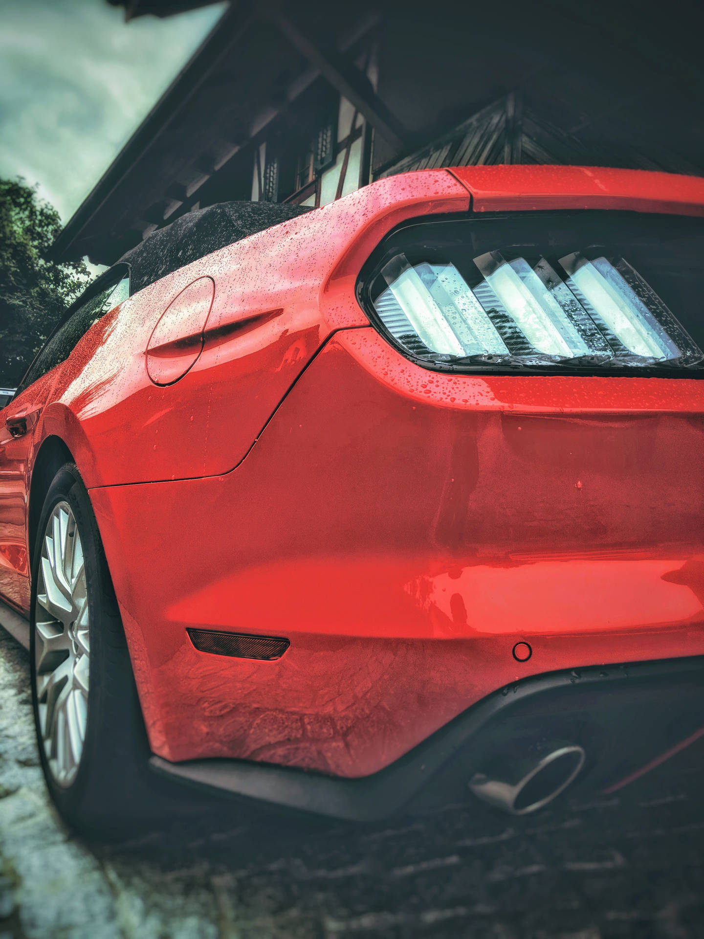 紅色跑車停放在戶外，表面帶有雨滴。