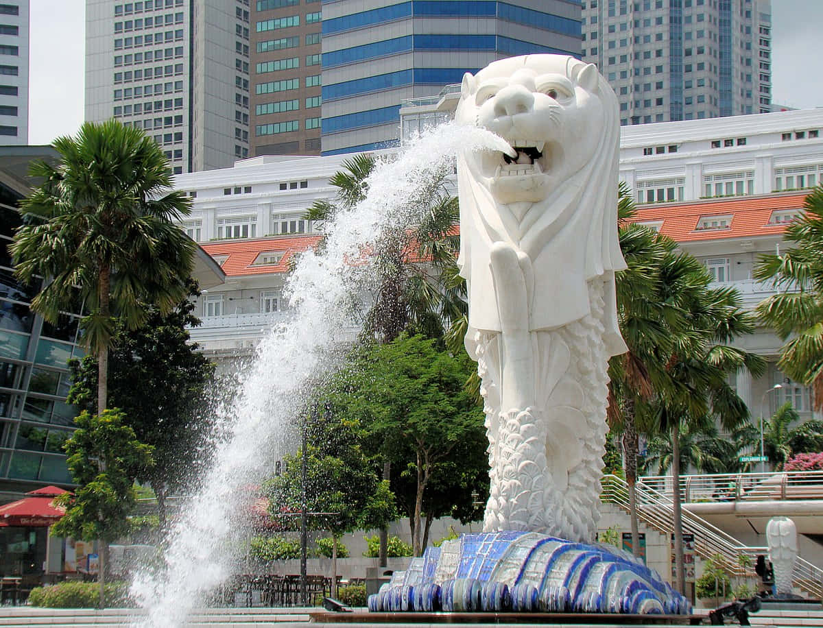 雄獅頭像 壁紙 — 一座高聳的白色魚尾獅雕像在繁忙的新加坡城市景觀中噴水，周圍有棕櫚樹和現代摩天大樓。