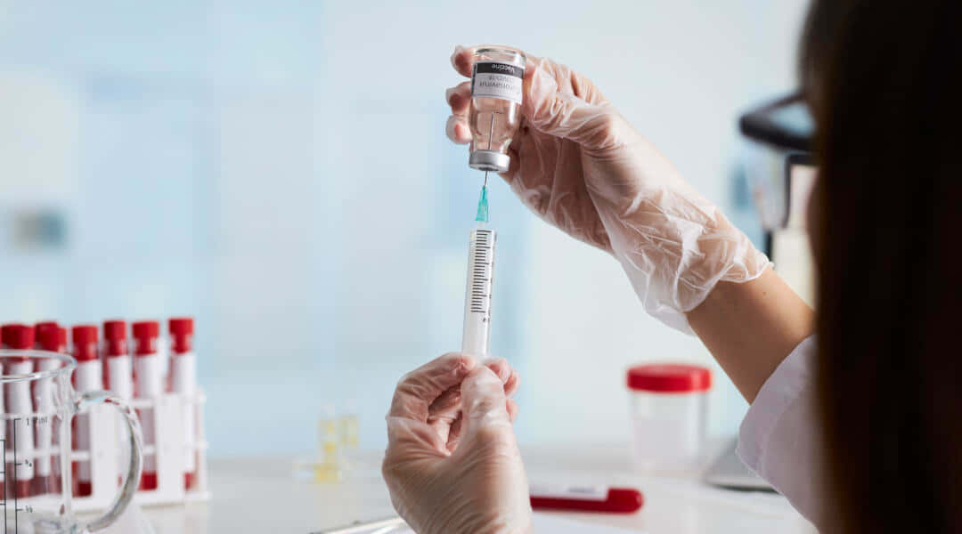 科學家在實驗室將疫苗抽取到注射器中