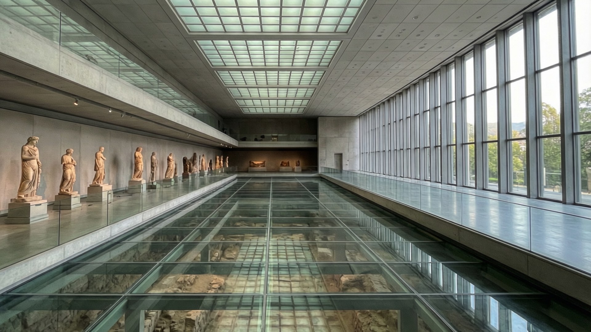 長長的博物館大廳，玻璃地板展示古代遺跡和沿牆的古典雕像。