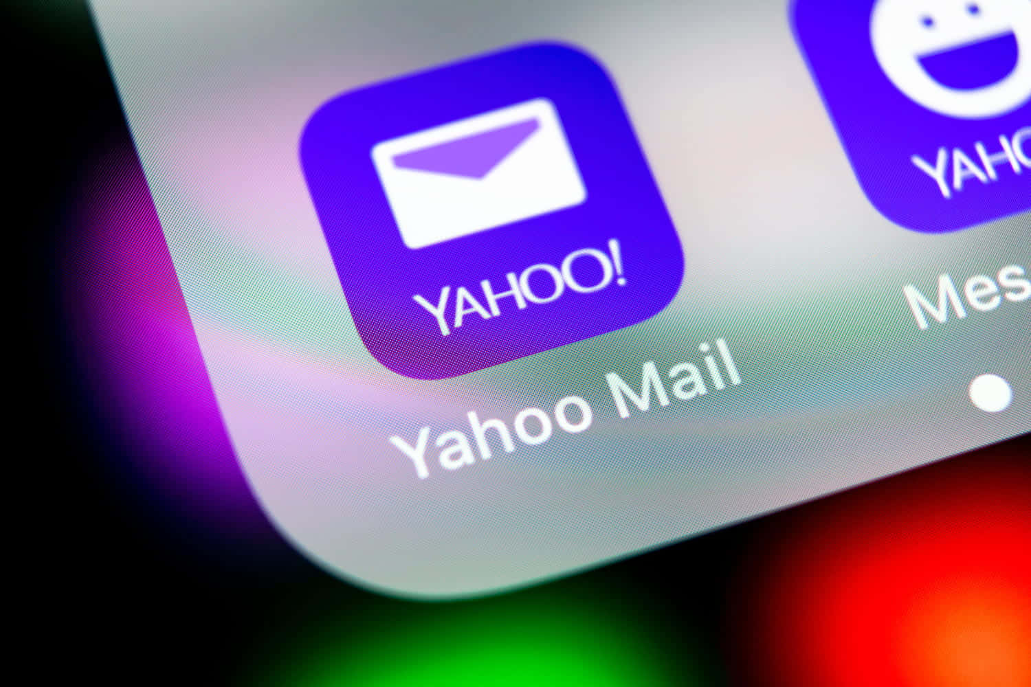雅虎標誌於純白背景 壁紙 — 智能手機屏幕特寫，顯示Yahoo Mail應用程式圖標，紫色和白色鮮豔，背景模糊多彩。