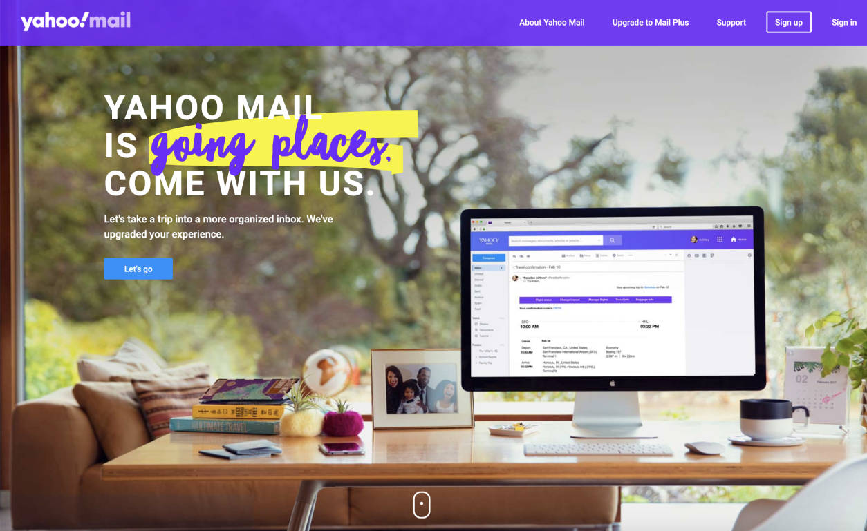 舒適的家庭辦公室，電腦在木桌上顯示 Yahoo Mail，靠近有綠樹的窗戶。