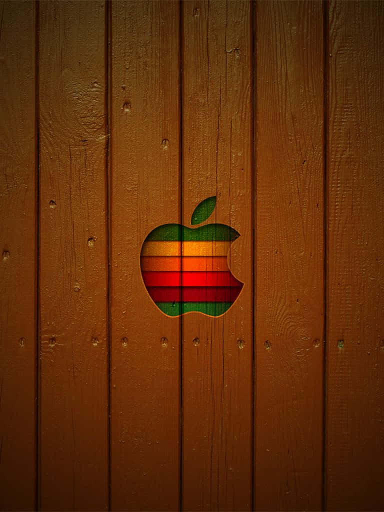 彩虹Apple標誌切割在木板上，帶有可見的木紋。