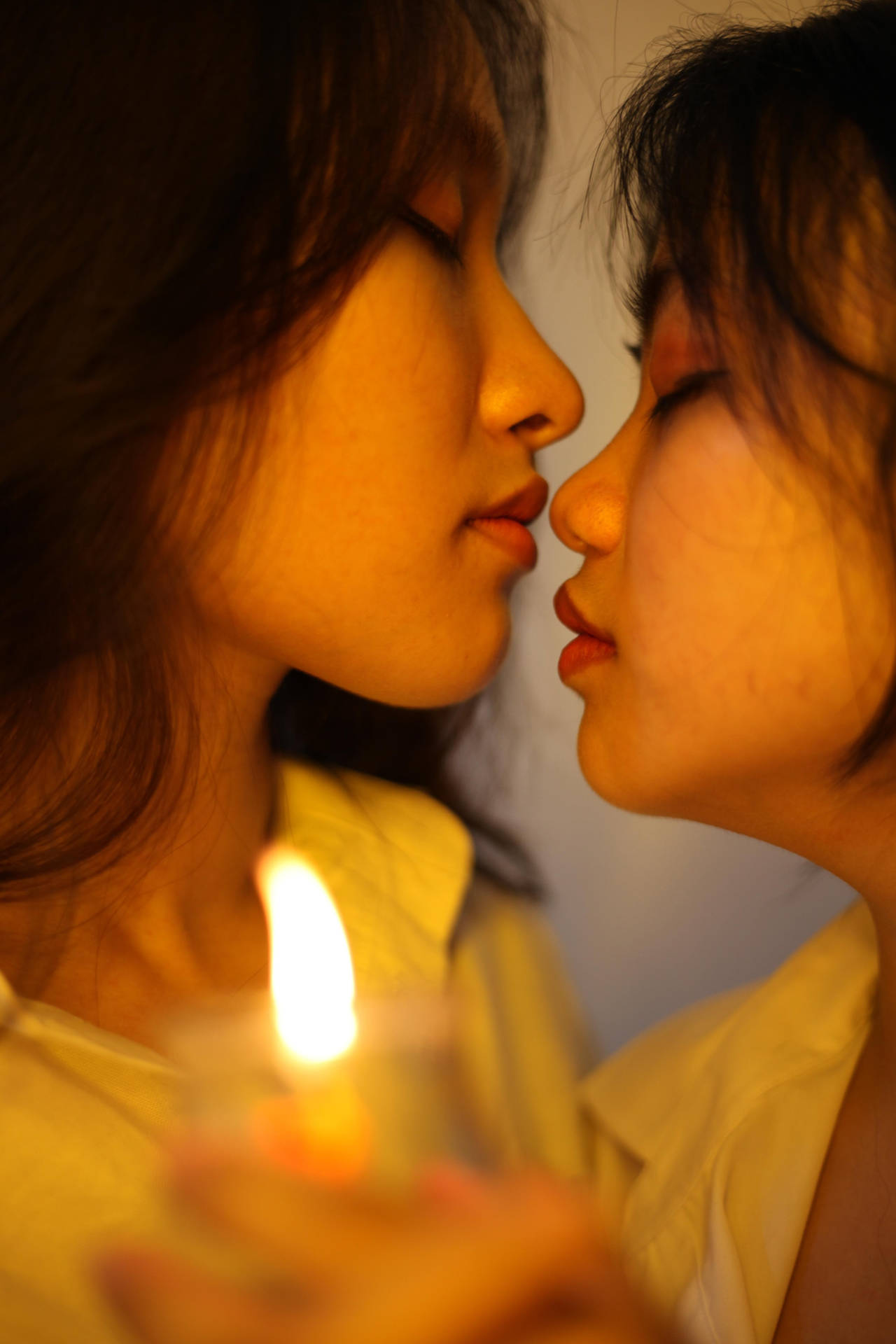 兩個女人側面輪廓在燭光下靠近