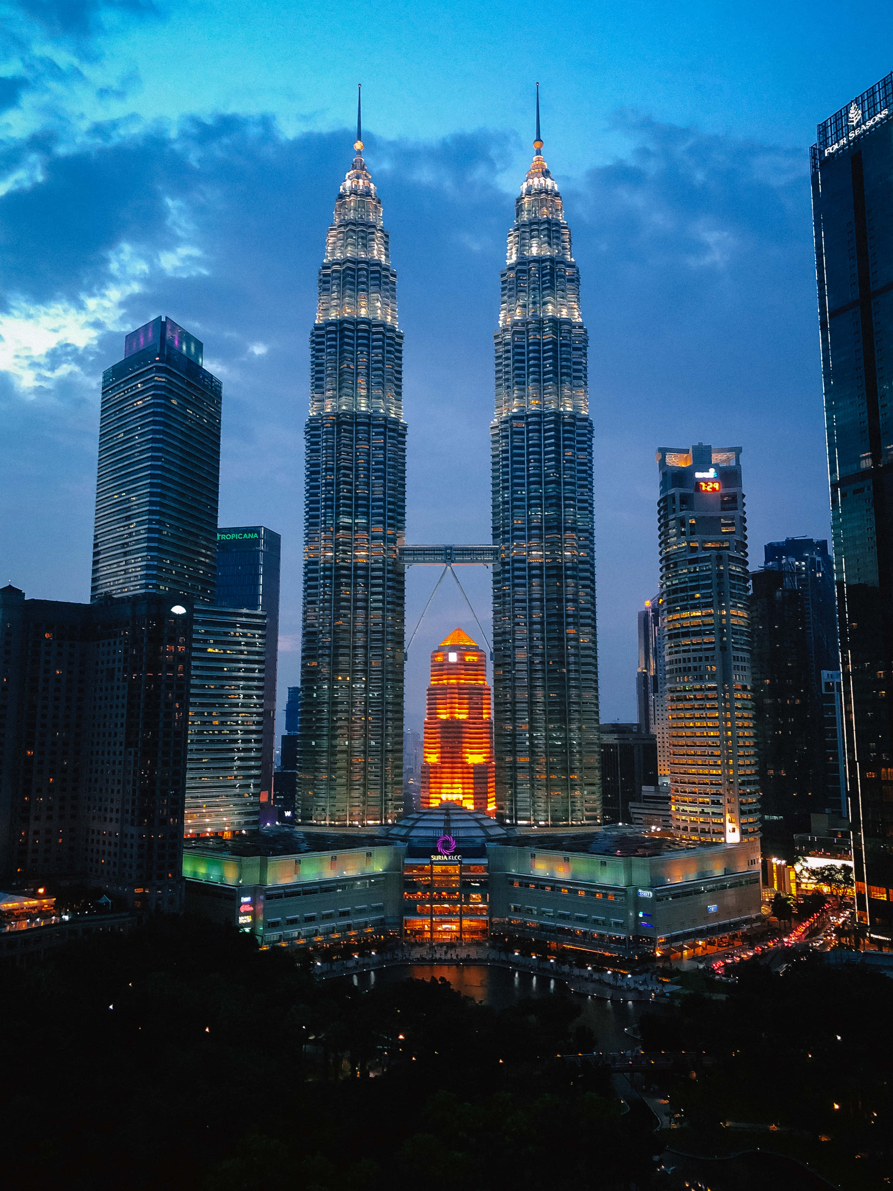 Malaysia 桌布 壁紙 — 雙子塔在暮色天空下閃耀，城市燈光倒映在下方水面。