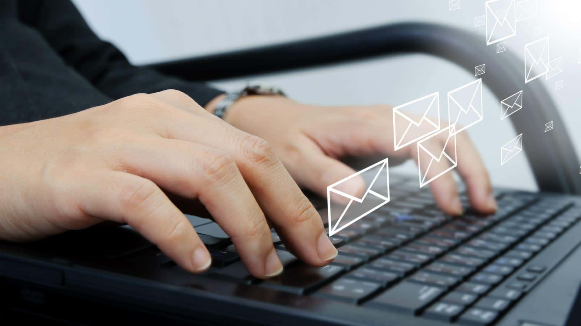 Email 桌布 壁紙 — 雙手在筆記型電腦鍵盤上打字，發光的白色電子郵件圖示漂浮在按鍵上方。