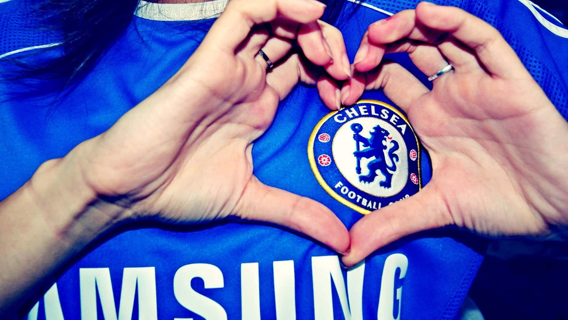 Chelsea 桌布 壁紙 — 雙手在車路士足球會球衣上形成心形，球會徽章置中。