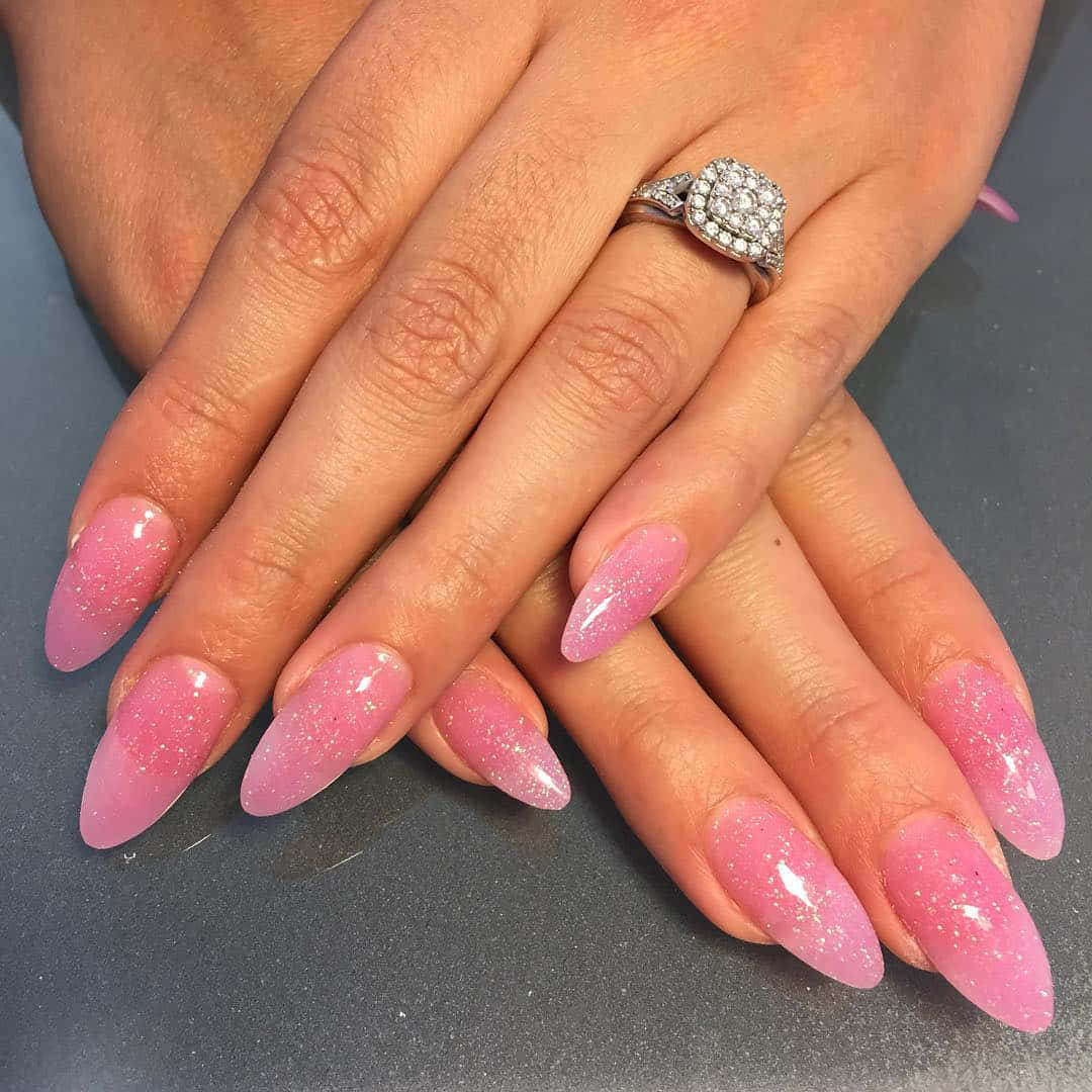 Pink Nails 桌布 壁紙 — 雙手特寫，長粉紅閃粉指甲，左手無名指戴鑽戒。