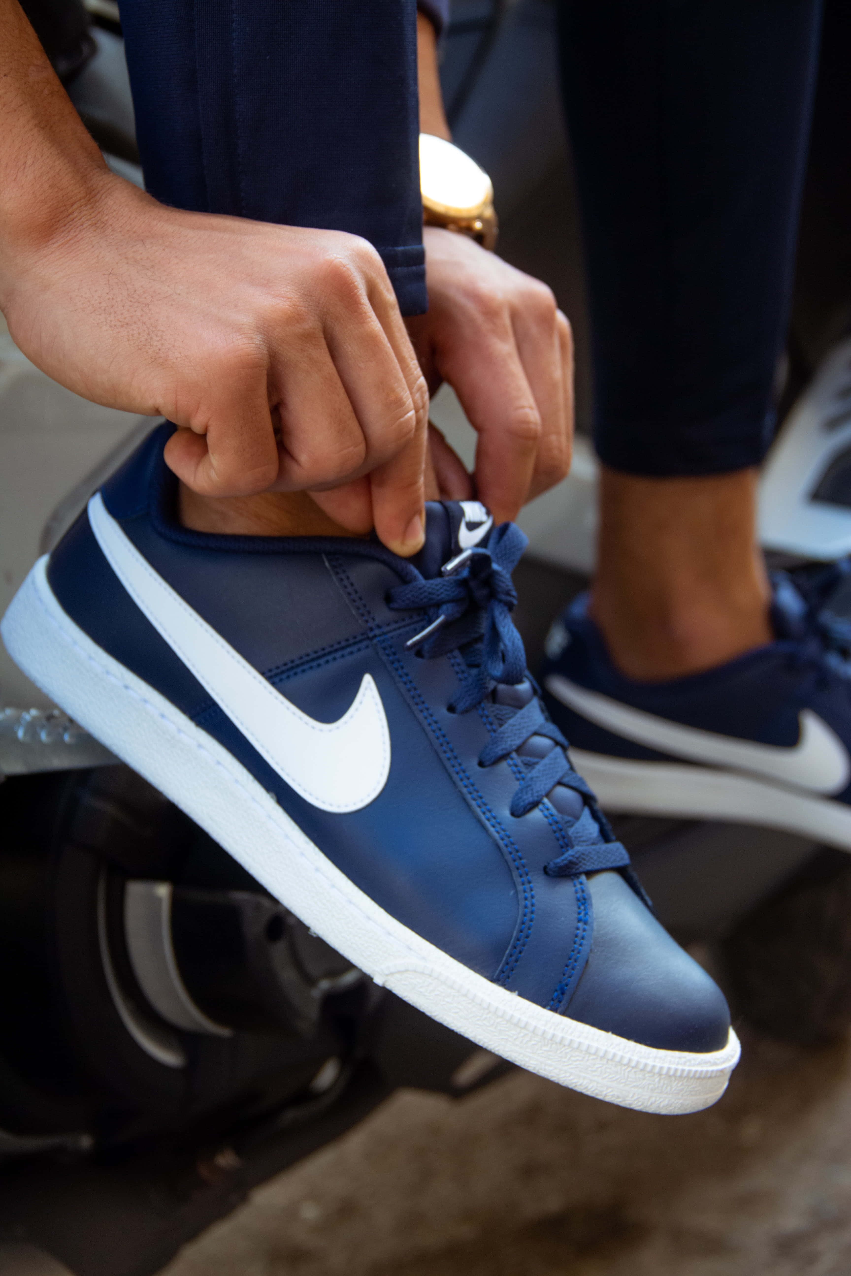 Navy Blue Shoes 桌布 壁紙 — 雙手綁緊海軍藍Nike運動鞋（白色swoosh標誌及鞋底）鞋帶的特寫。