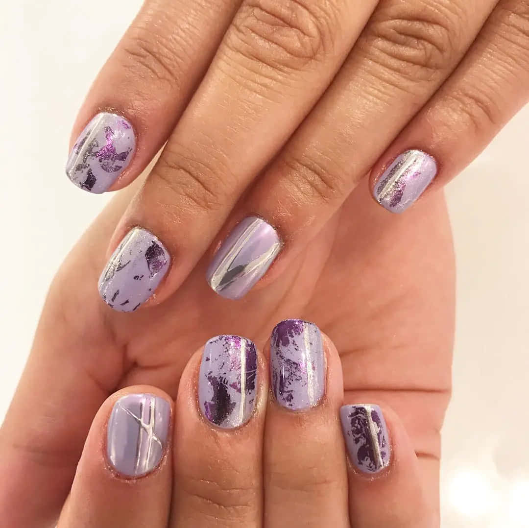 Spring Nails 桌布 壁紙 — 雙手近鏡，指甲帶有薰衣草色和銀色閃粉，並飾有抽象紫色潑濺圖案。