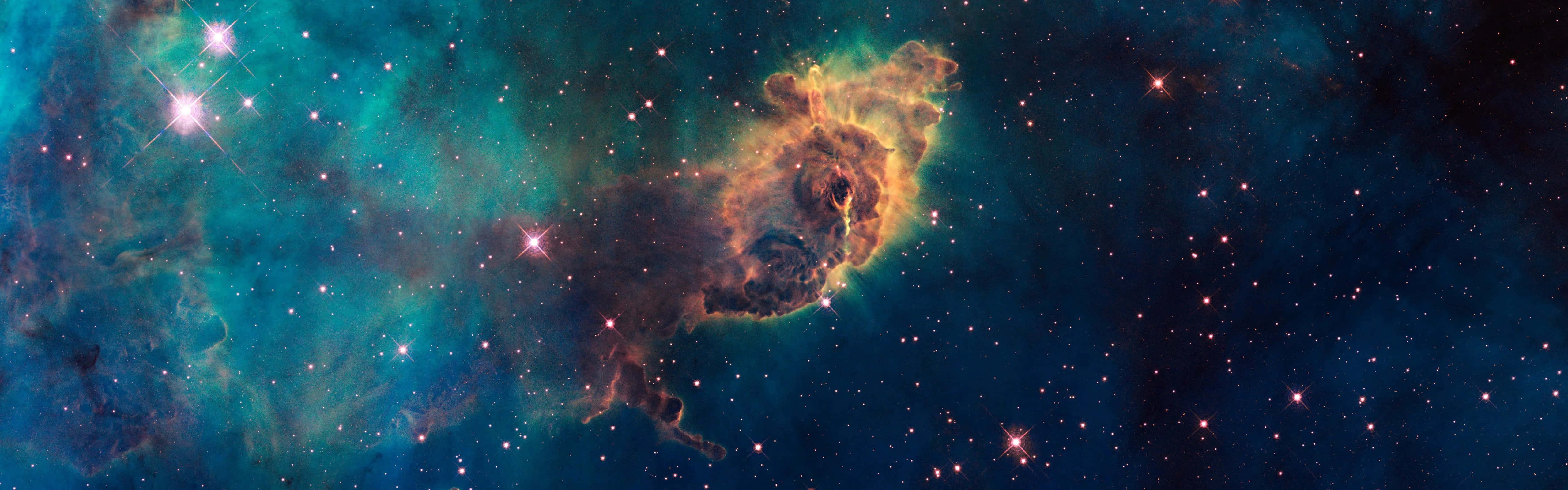 在深空中與星星一起發光的充滿活力的青綠色和橙色星雲。
