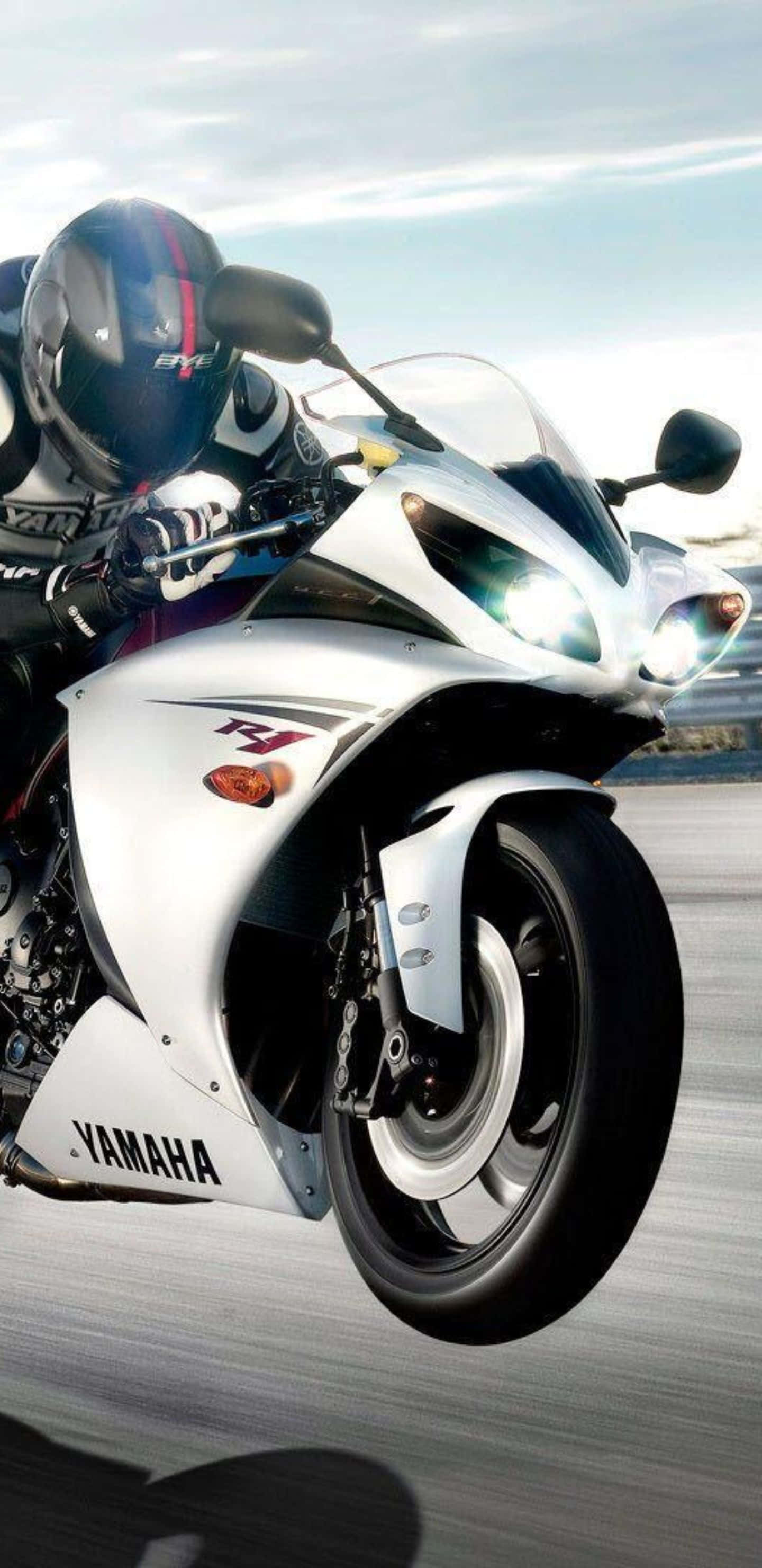 雙輪冒險：準備好用 Pixel 3XL 自行車征服旅程！ 壁紙 — 一架白色Yamaha R1電單車連同車手在晴朗天空下的賽道上傾斜入彎。