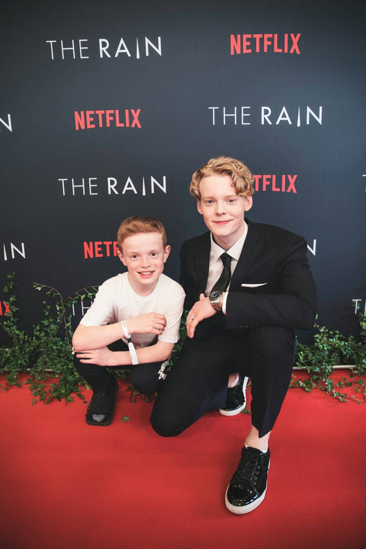 兩位年輕演員在 Netflix 的 The Rain 活動中一起在紅地毯上擺姿勢。