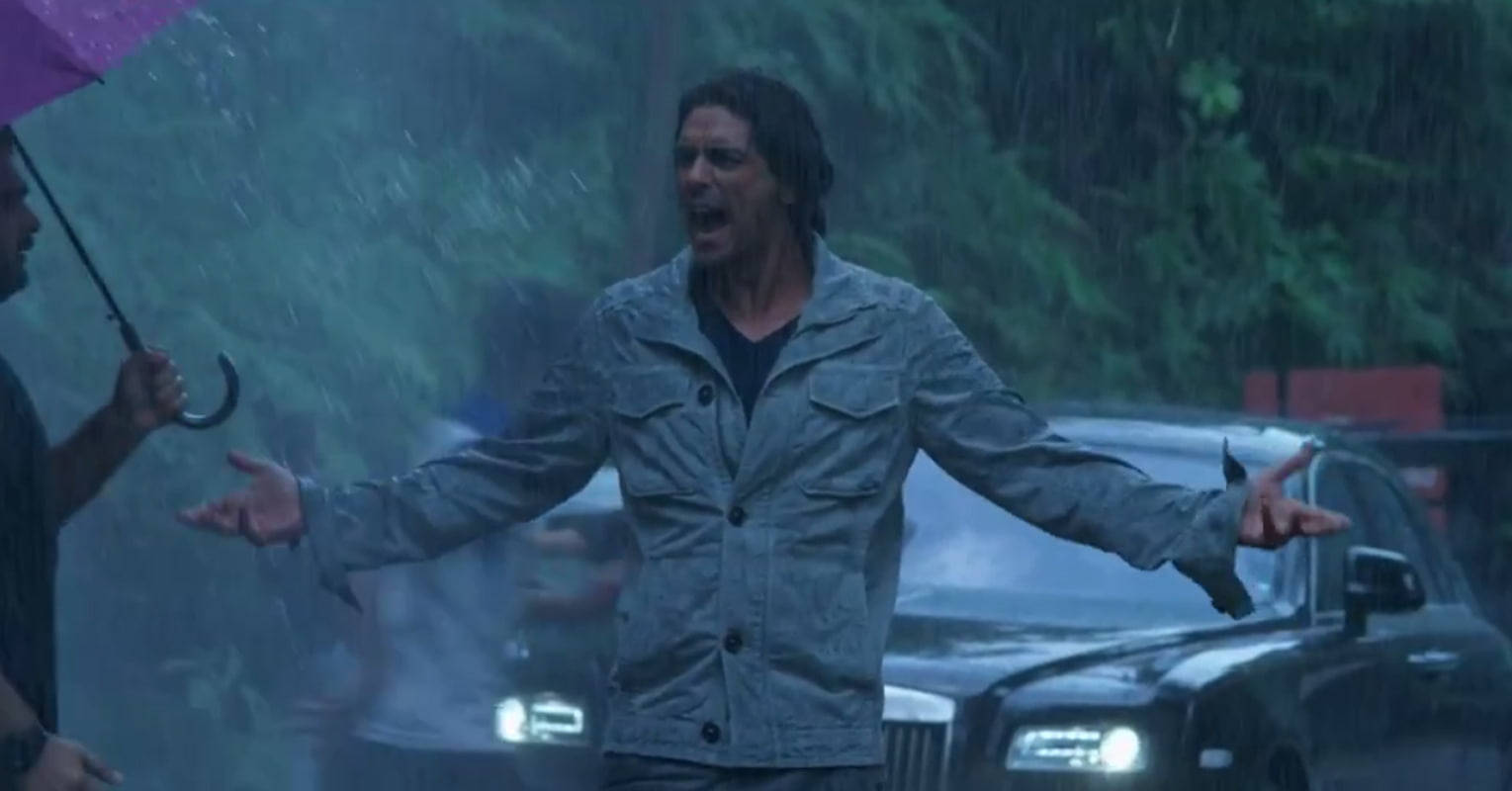 男人在暴雨中張開雙臂大喊，靠近一輛車。
