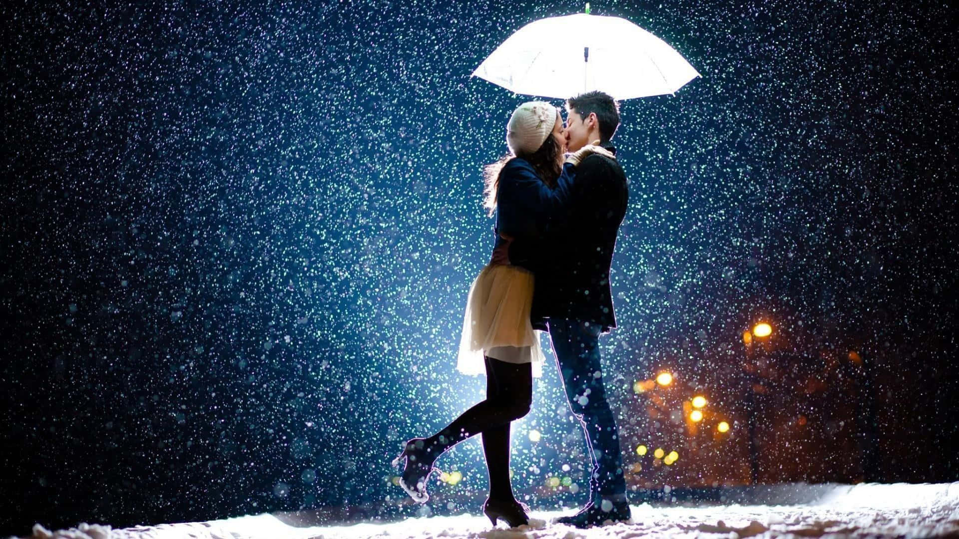 雨中漫步，共撐一把傘 壁紙 — 一對情侶在發光的白色雨傘下接吻，雪花飄落在黑暗的城市夜晚，溫暖的路燈照耀著。