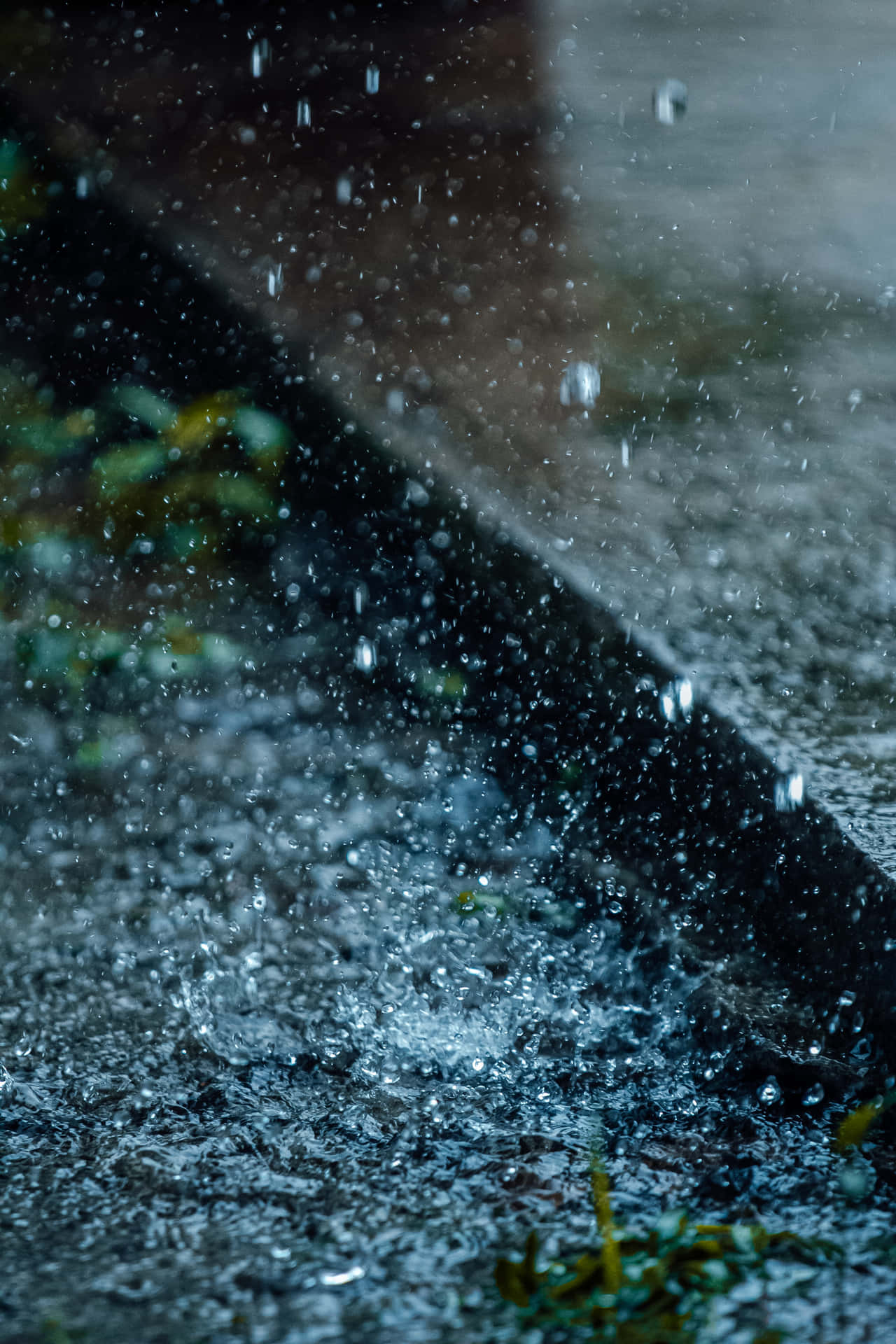 黃昏時雨滴濺在濕漉漉的人行道上