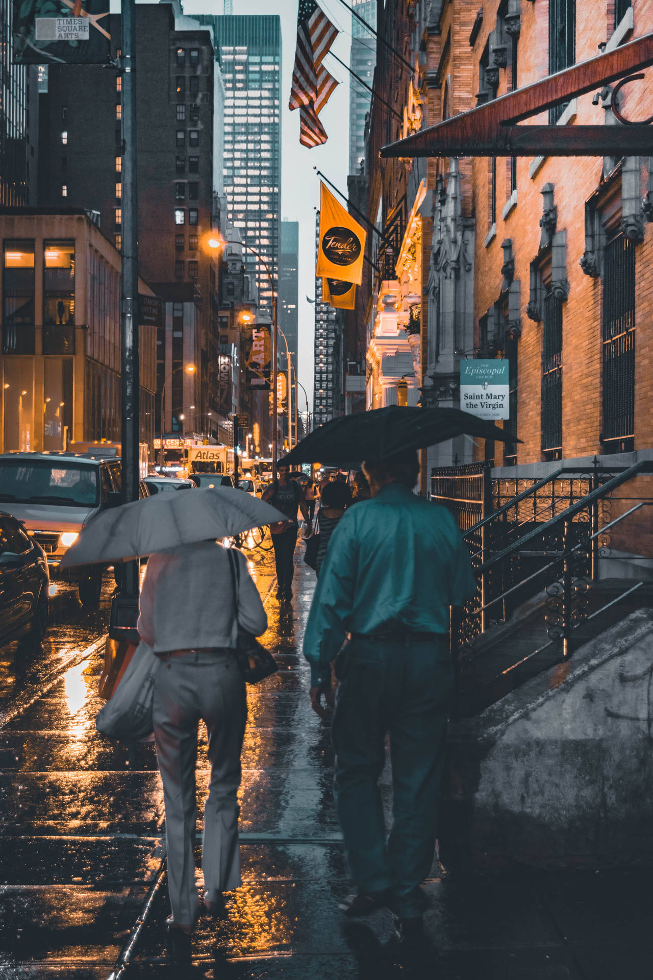 兩個人在夜晚的城市街道上撐傘雨中行走
