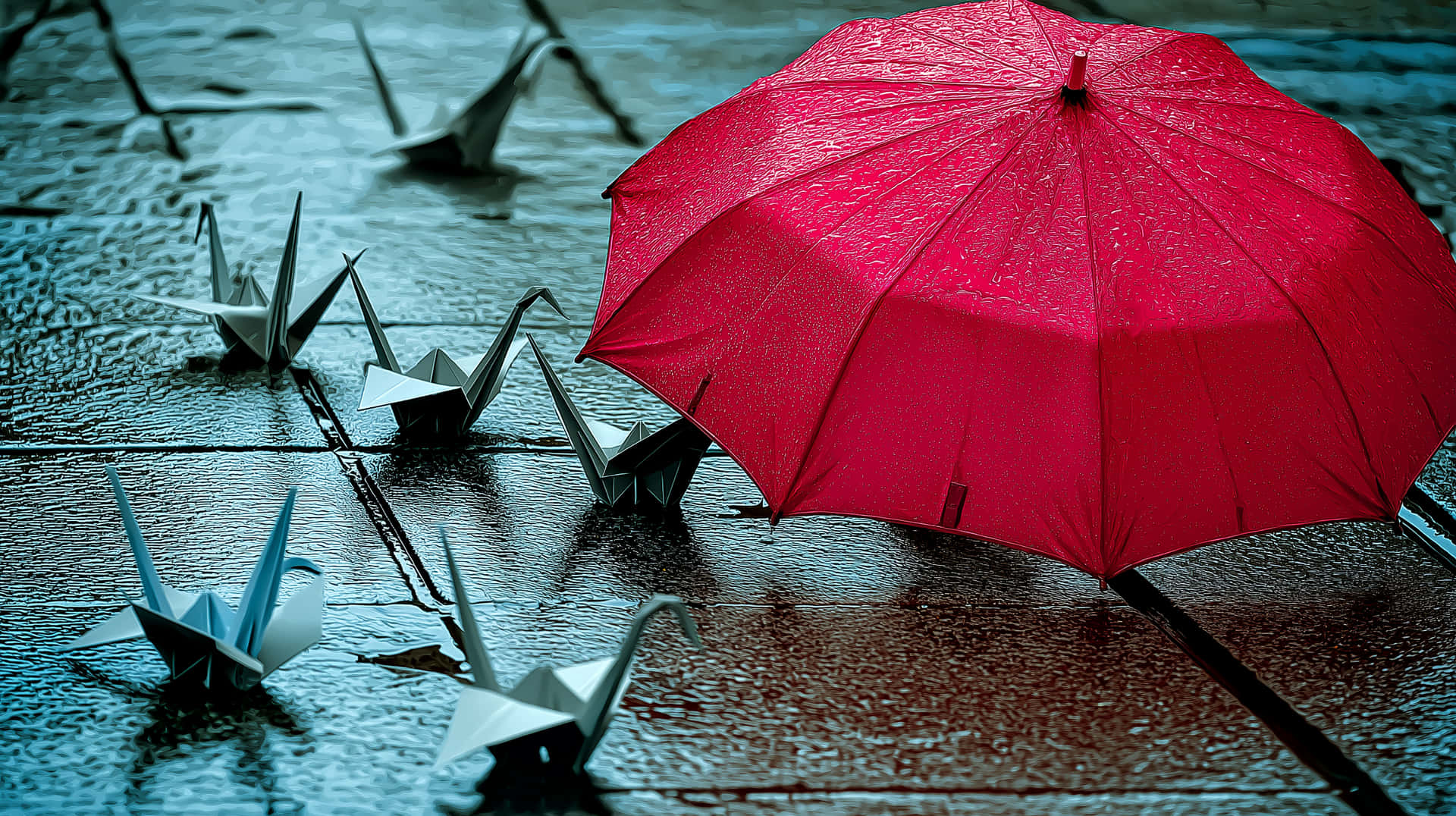 紅色雨傘在雨中保護著濕石板路上的紙鶴。