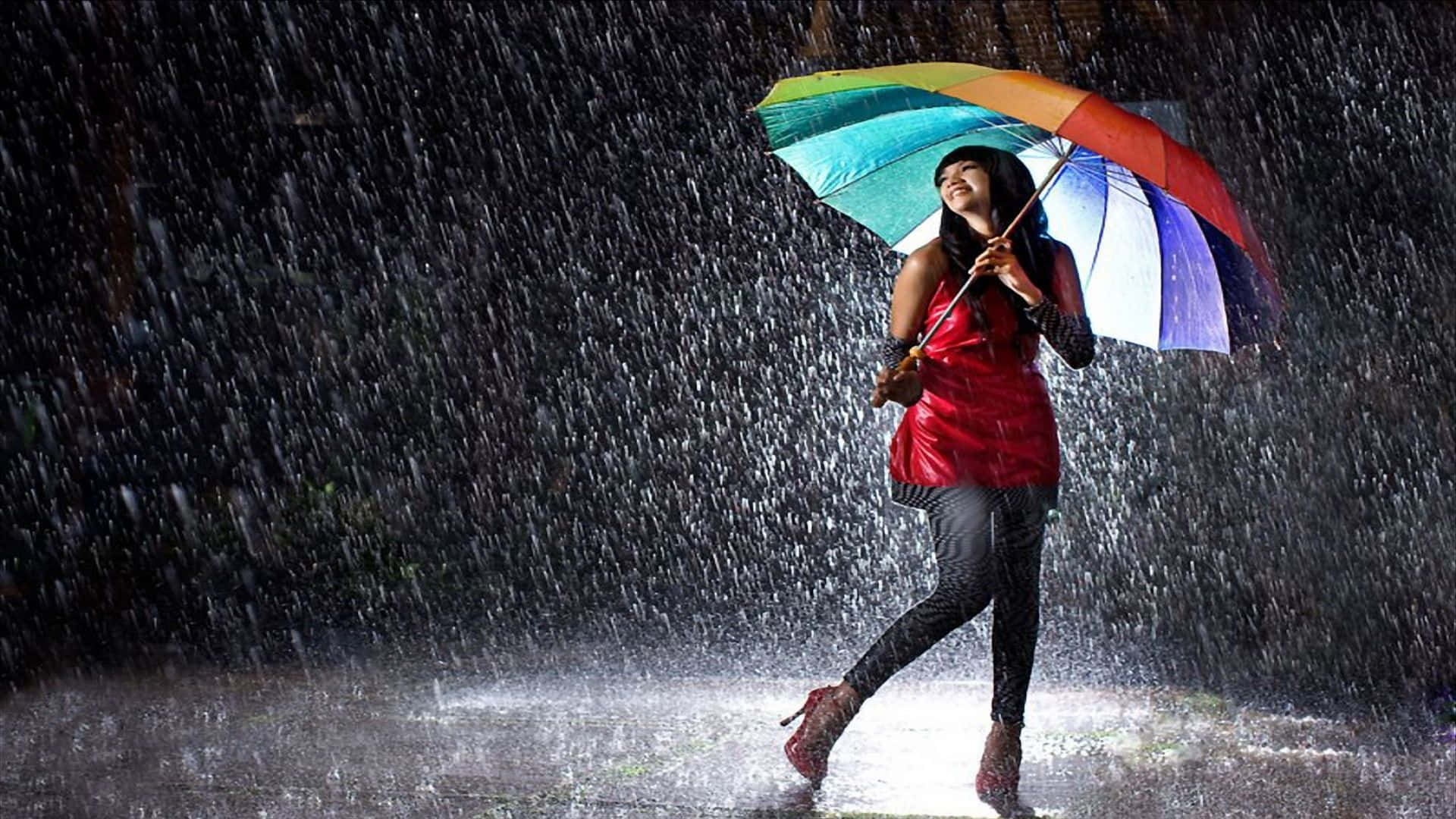 女性在滂沱大雨中於彩虹傘下微笑，身穿紅色外套和高跟鞋。