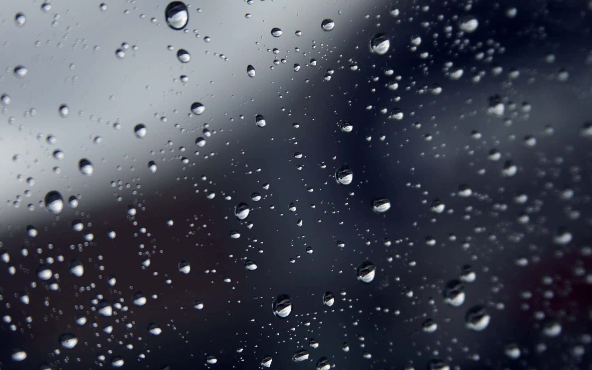 玻璃上的雨滴，背景模糊灰色