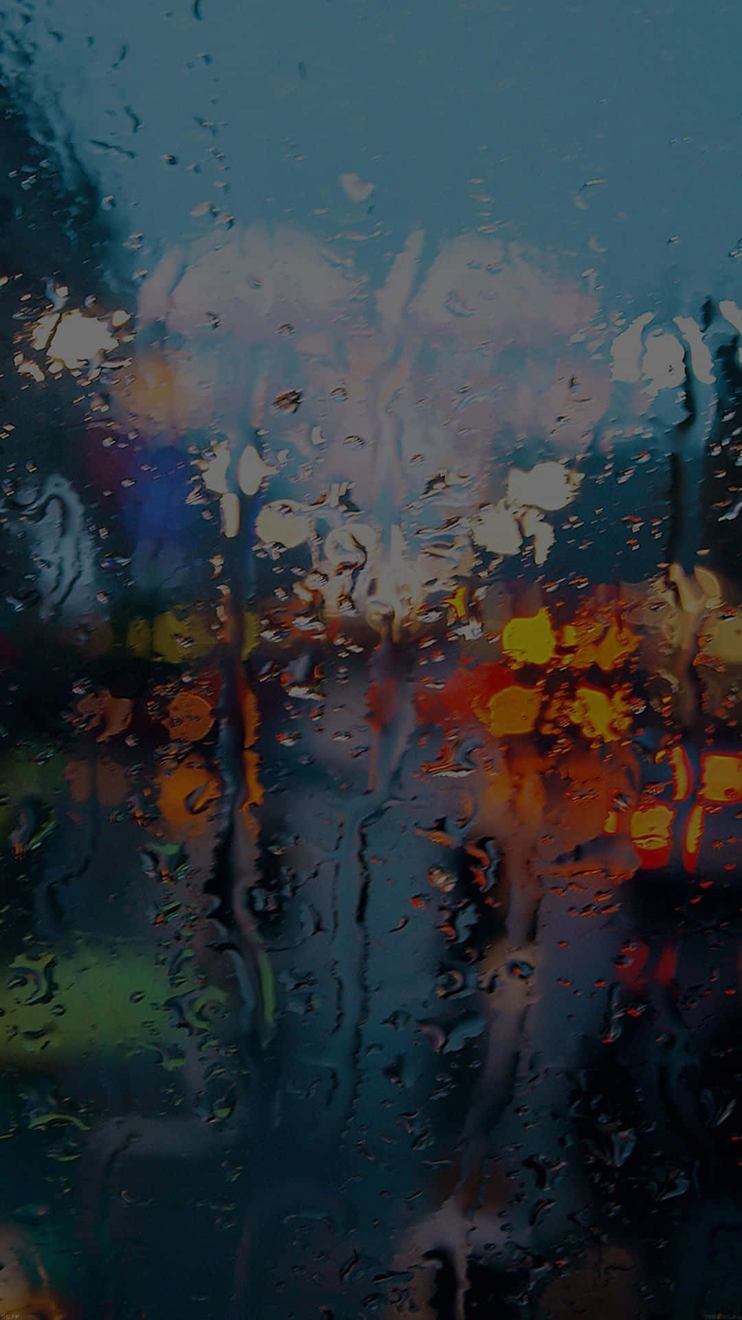 雨點在窗戶上流動，顯示夜間模糊的城市燈光。