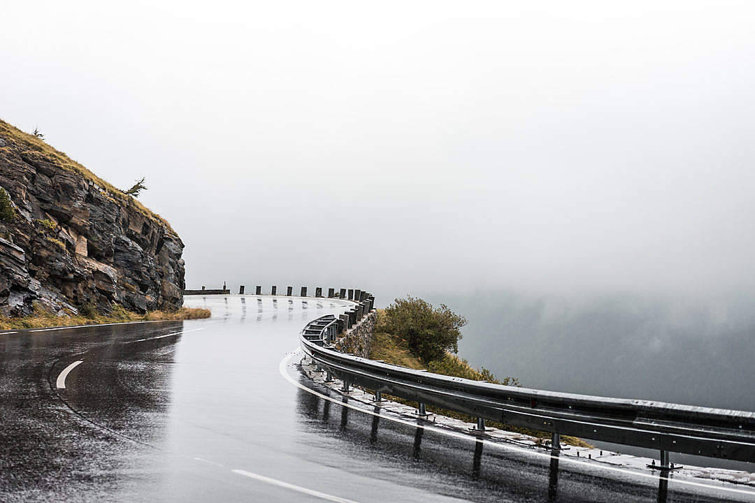 蜿蜒的山路穿過迷霧，設有護欄和岩石峭壁。