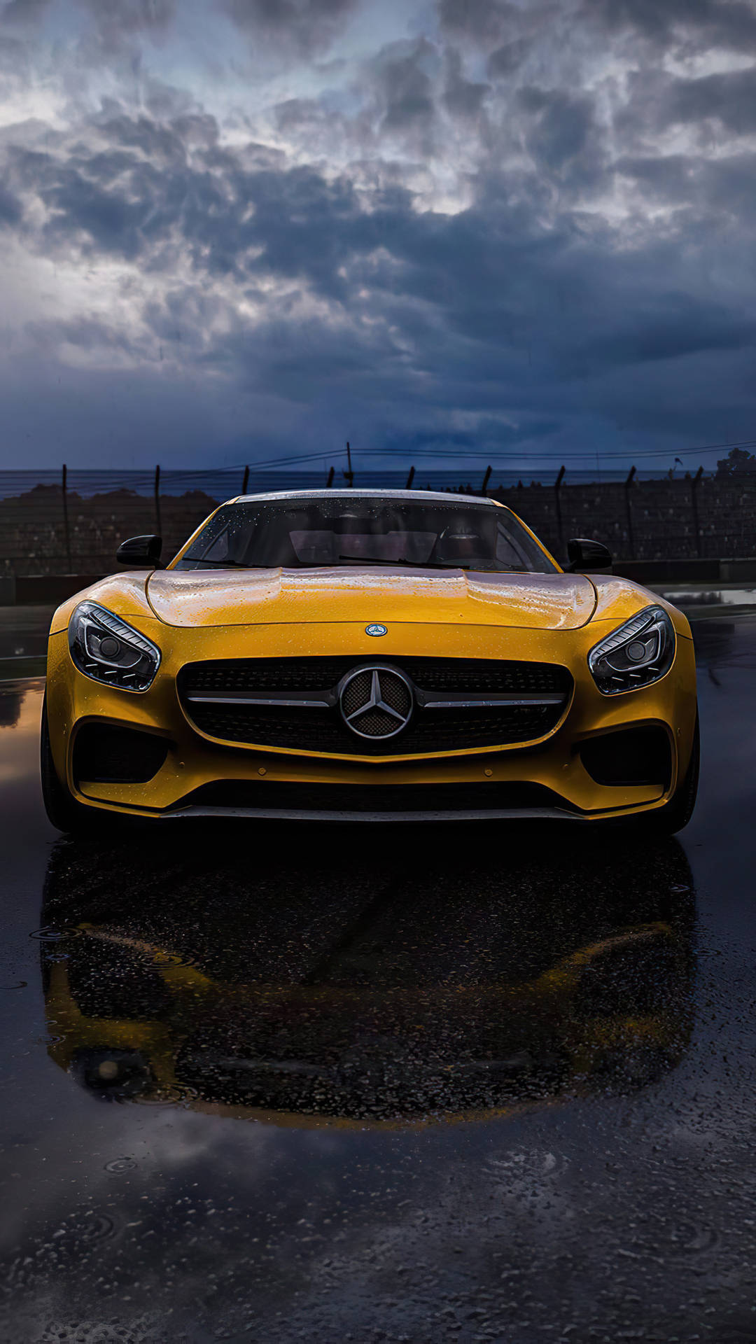 黃色Mercedes-AMG GT跑車在潮濕賽道上，暴風雨天空下帶有倒影。