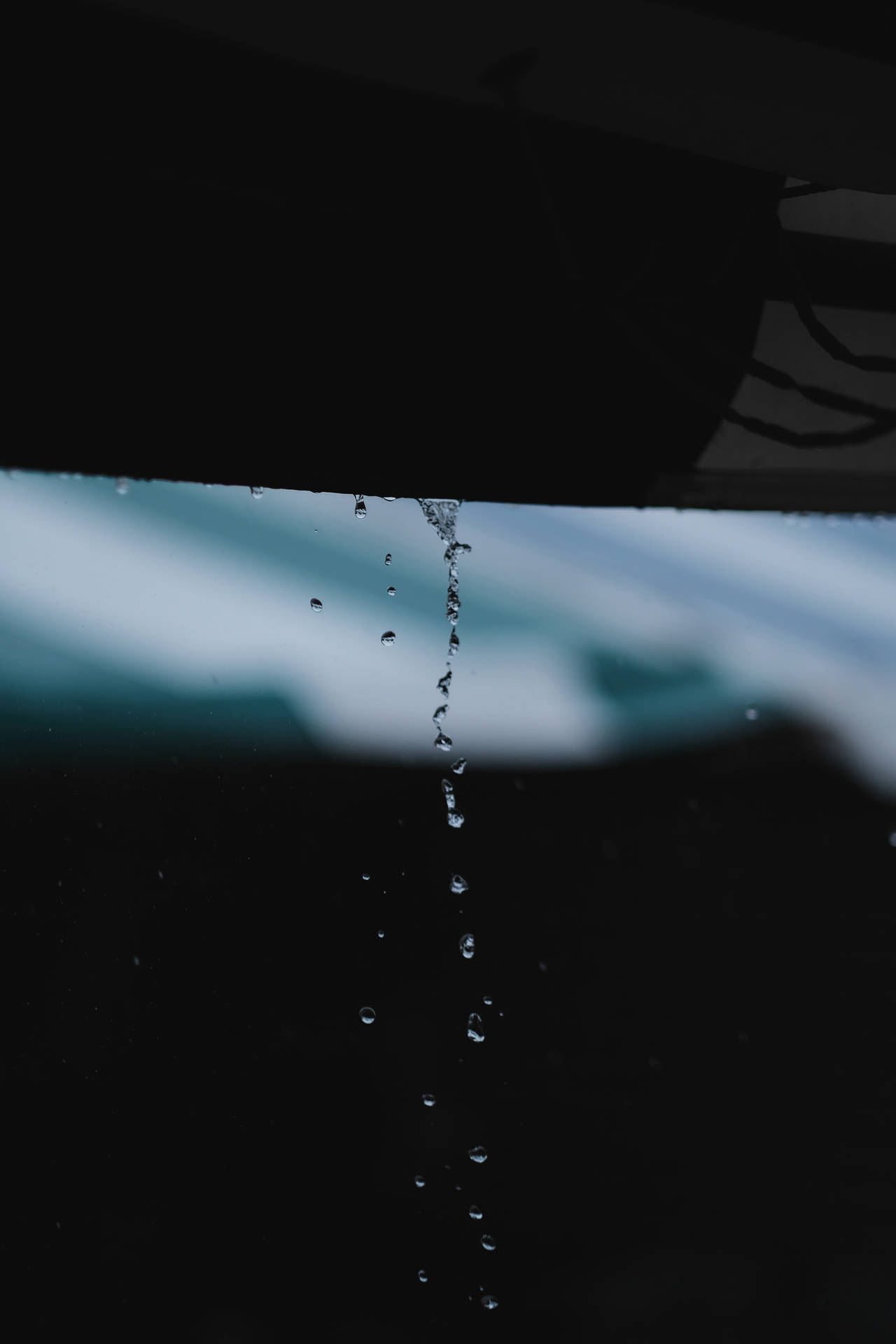 雨滴從車窗落下，背景是模糊的天空。