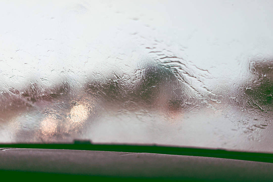 汽車擋風玻璃上的雨滴，帶有綠色雨刮片。