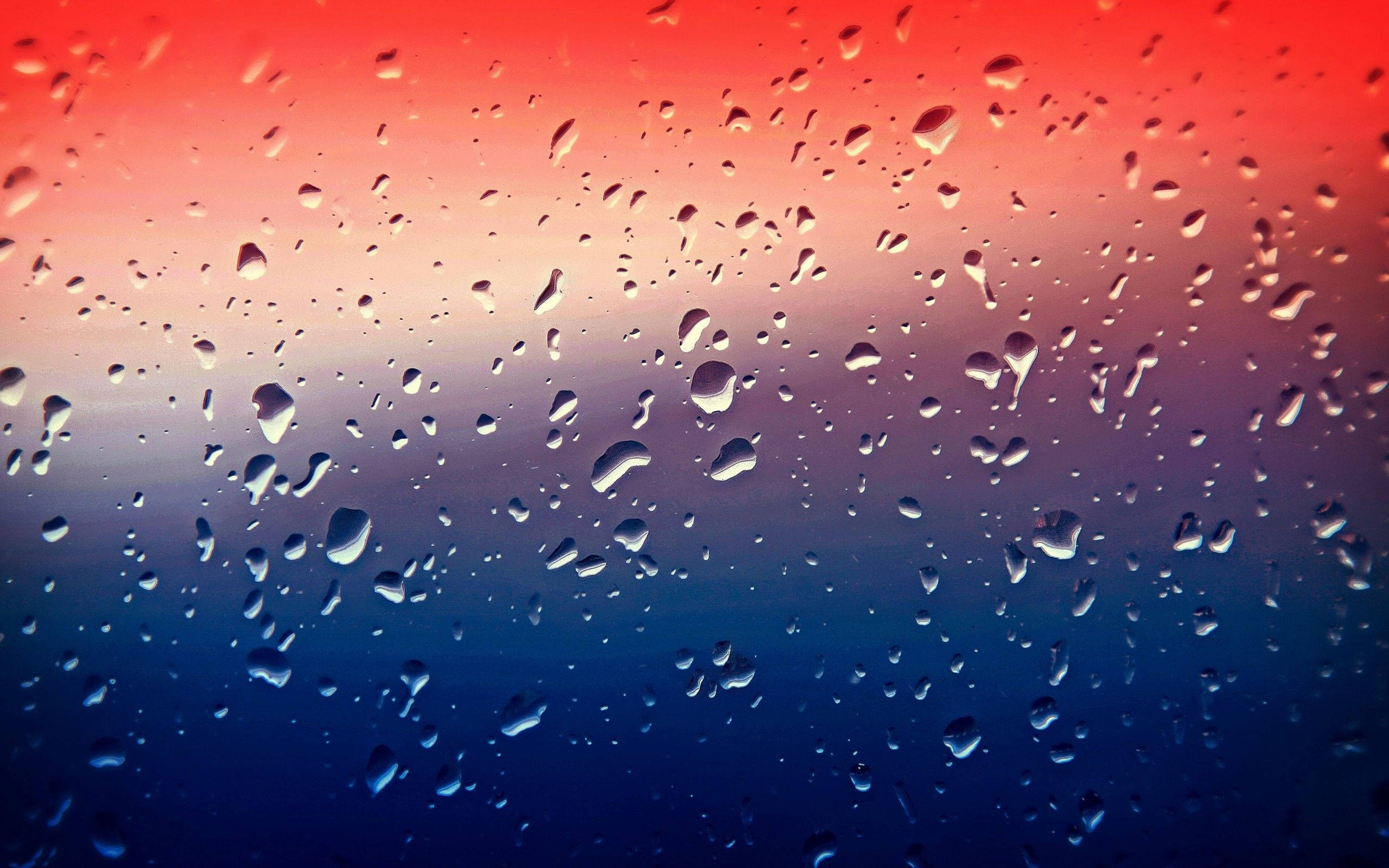 漸變動畫 桌布 壁紙 — 雨滴依附在窗戶上，展現出從火紅到深藍的鮮豔漸變天空。