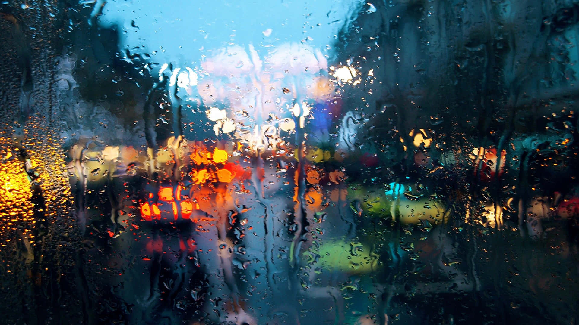 Rainy Day 桌布 壁紙 — 雨滴劃過窗戶，將暮色天空下充滿活力的城市燈光模糊成色彩繽紛的散景。