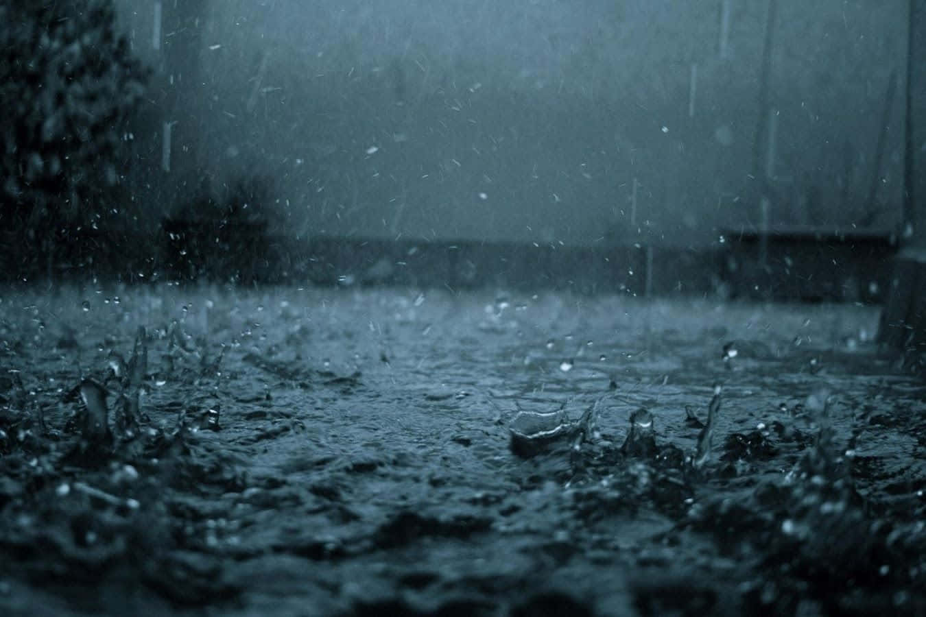 暴風雨天氣中雨滴濺在潮濕的路面上。